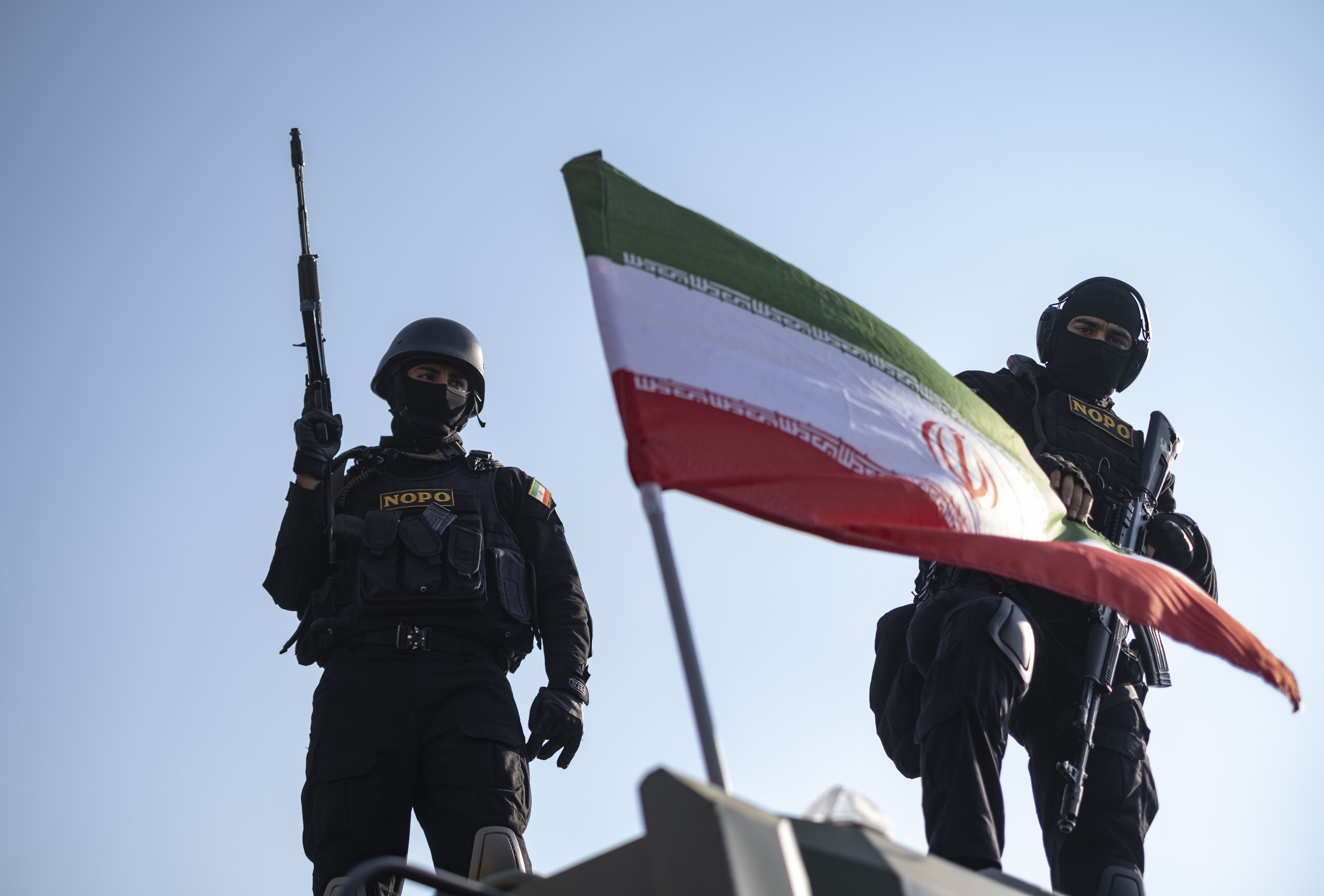 Armed Iranian special police stand on an armored vehicle with a national flag during a pro-government rally in Tehran.