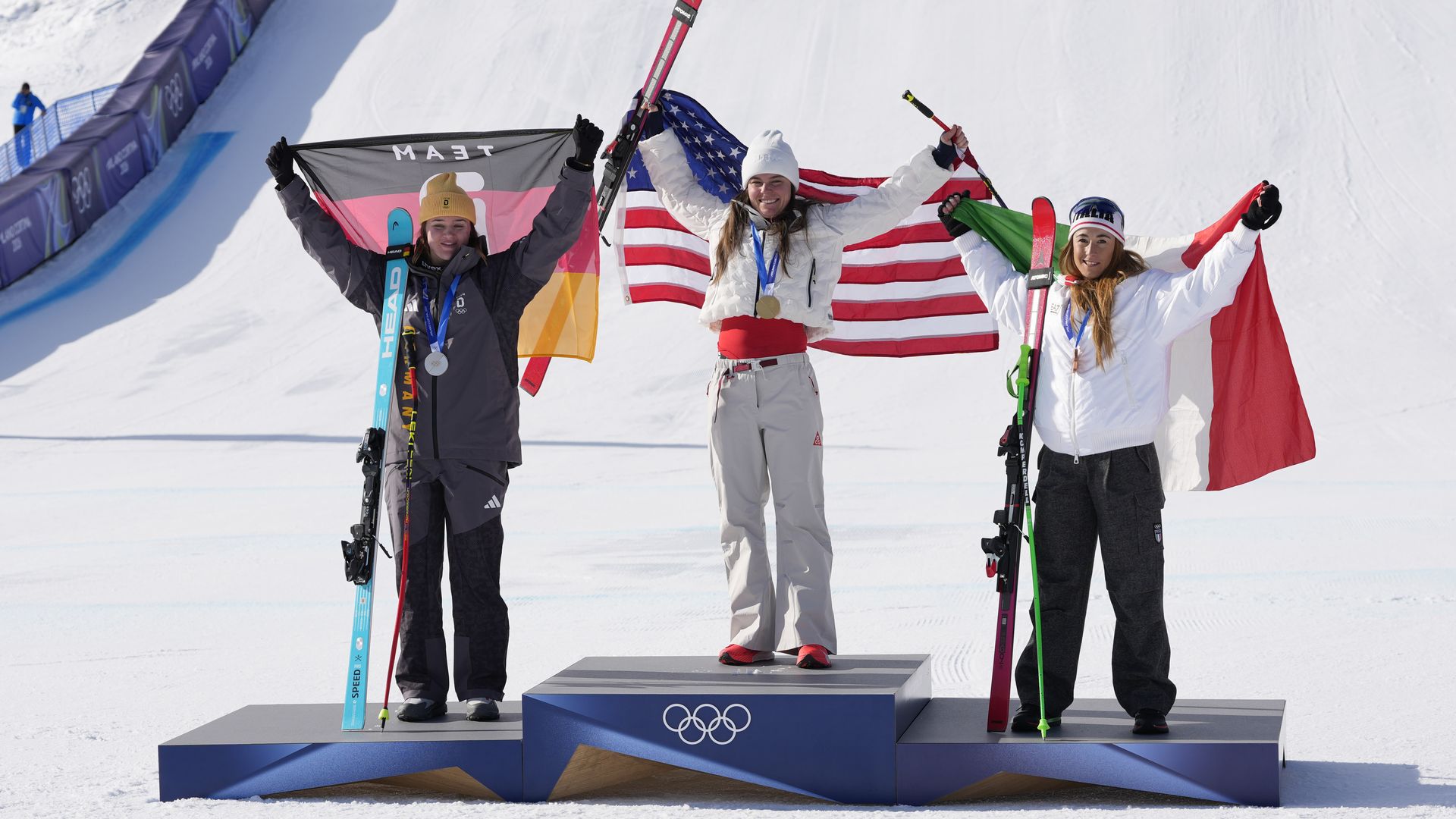 Three women skiers stand on an olympic podium