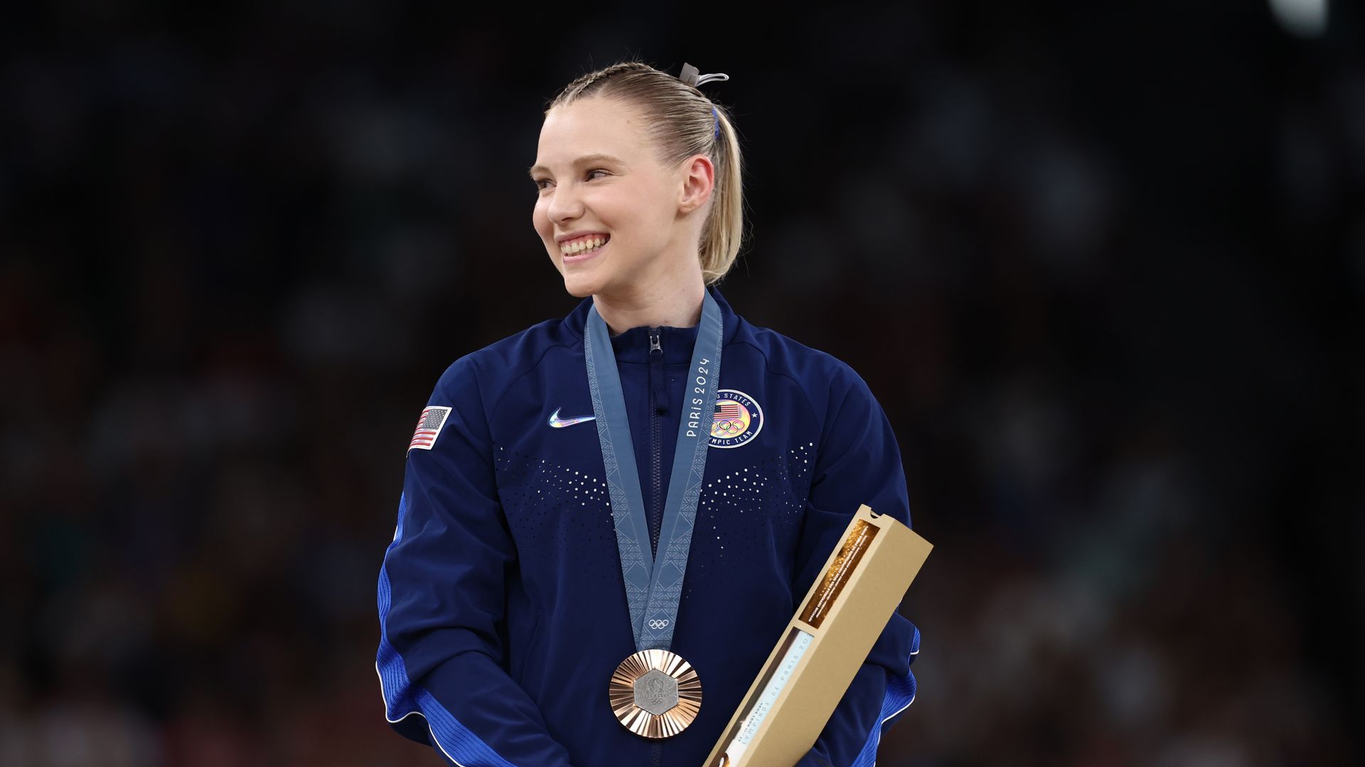 A woman wearing a bronze medal. 