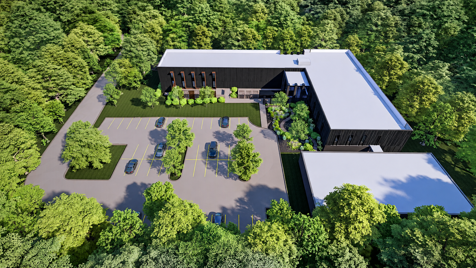 Aerial view of a modern dark building complex in a dense forest, with a parking lot marked by yellow lines and several cars, and a curved driveway to the entrance.
