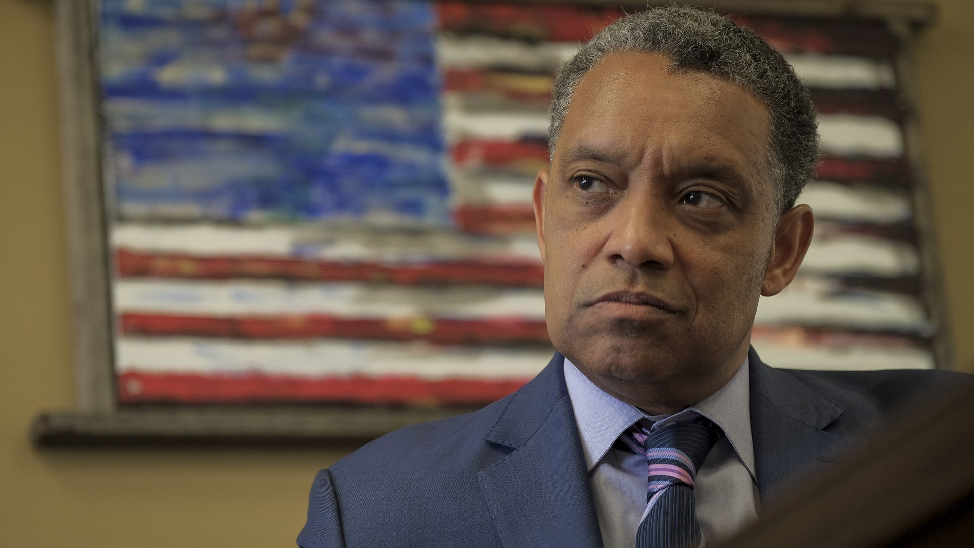 Washington, D.C. Attorney General Karl Racine sits for an interview in his office in front of an American flag in March 2019.
