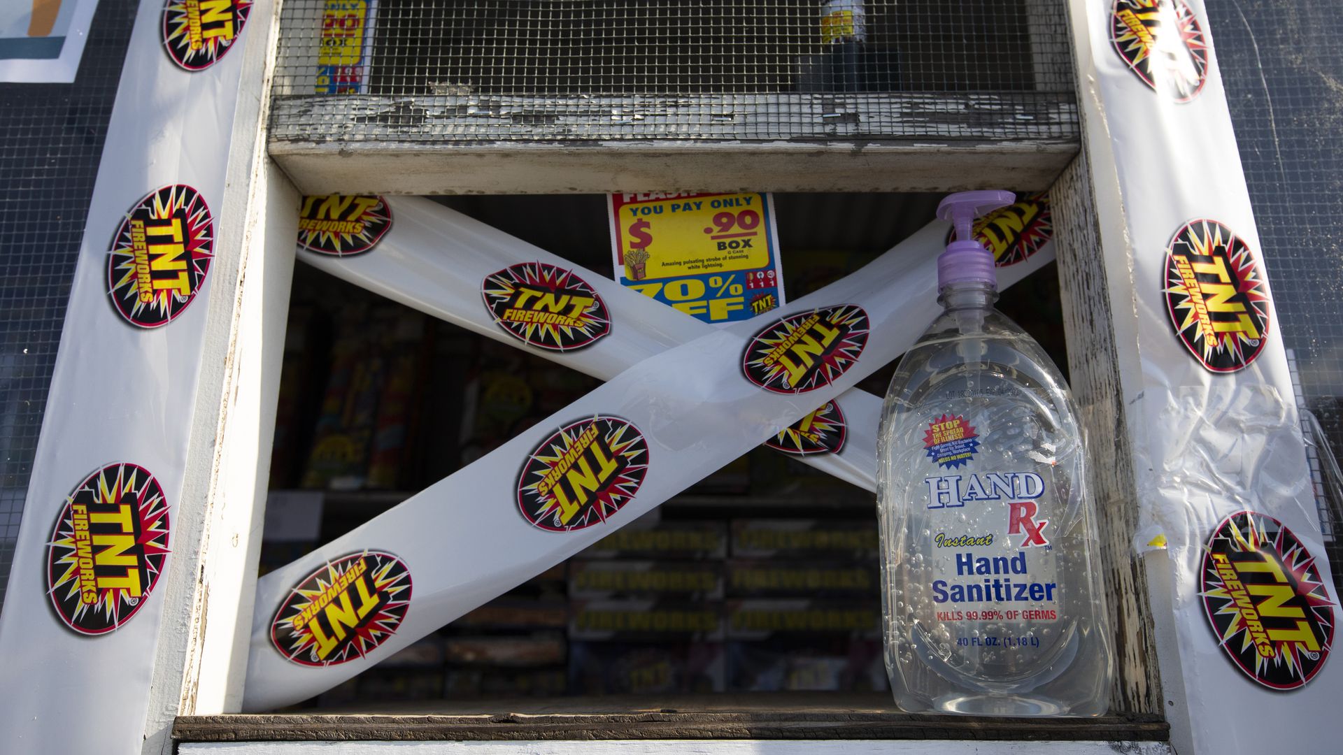 A firework stand with hand sanitizer and tape across the window