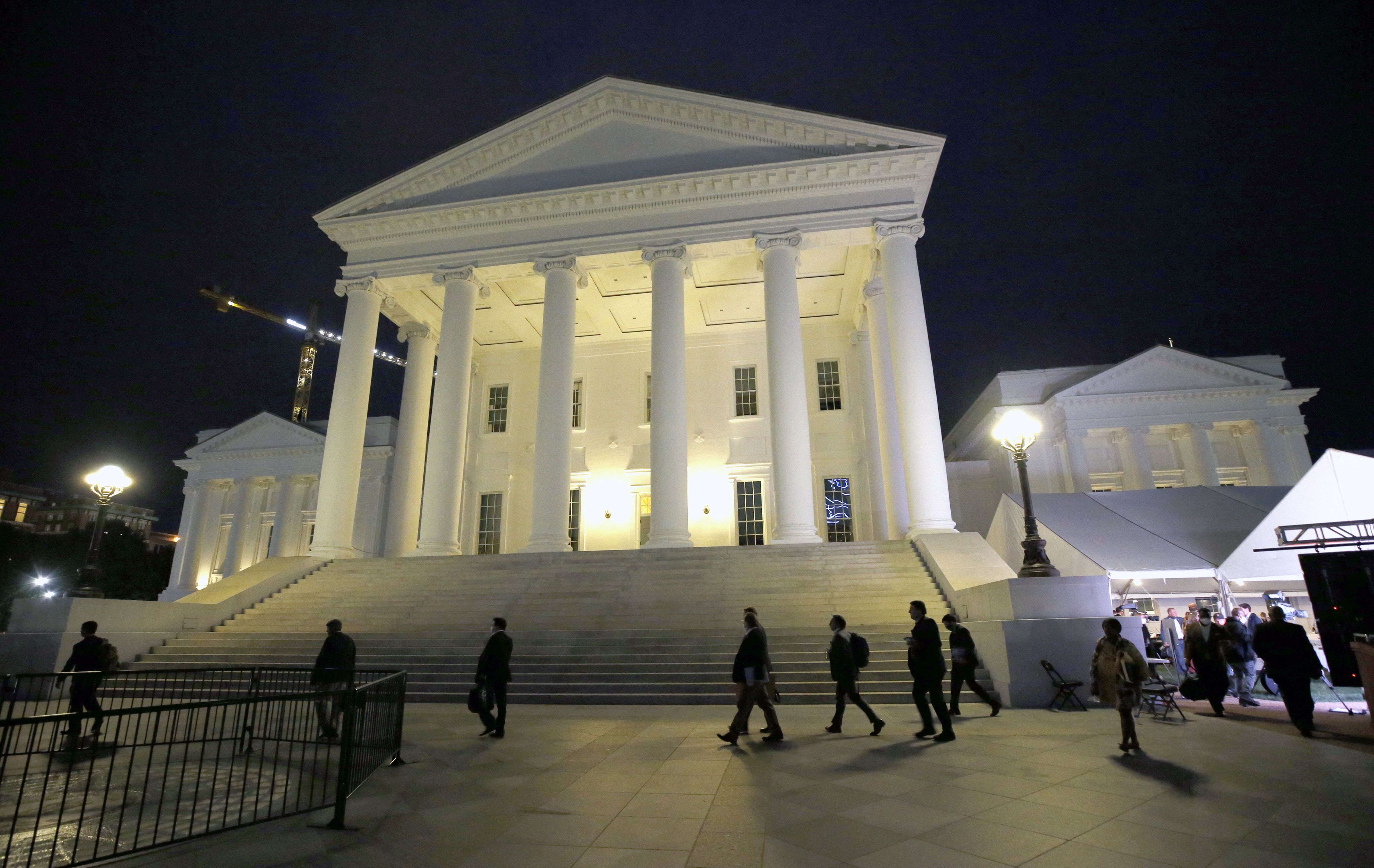  House of Delegates members walk past the south portico at the Virginia State Capitol in Richmond, Va., Wednesday, April 22, 2020. (Bob Brown/Richmond Times-Dispatch via AP, Pool, File)