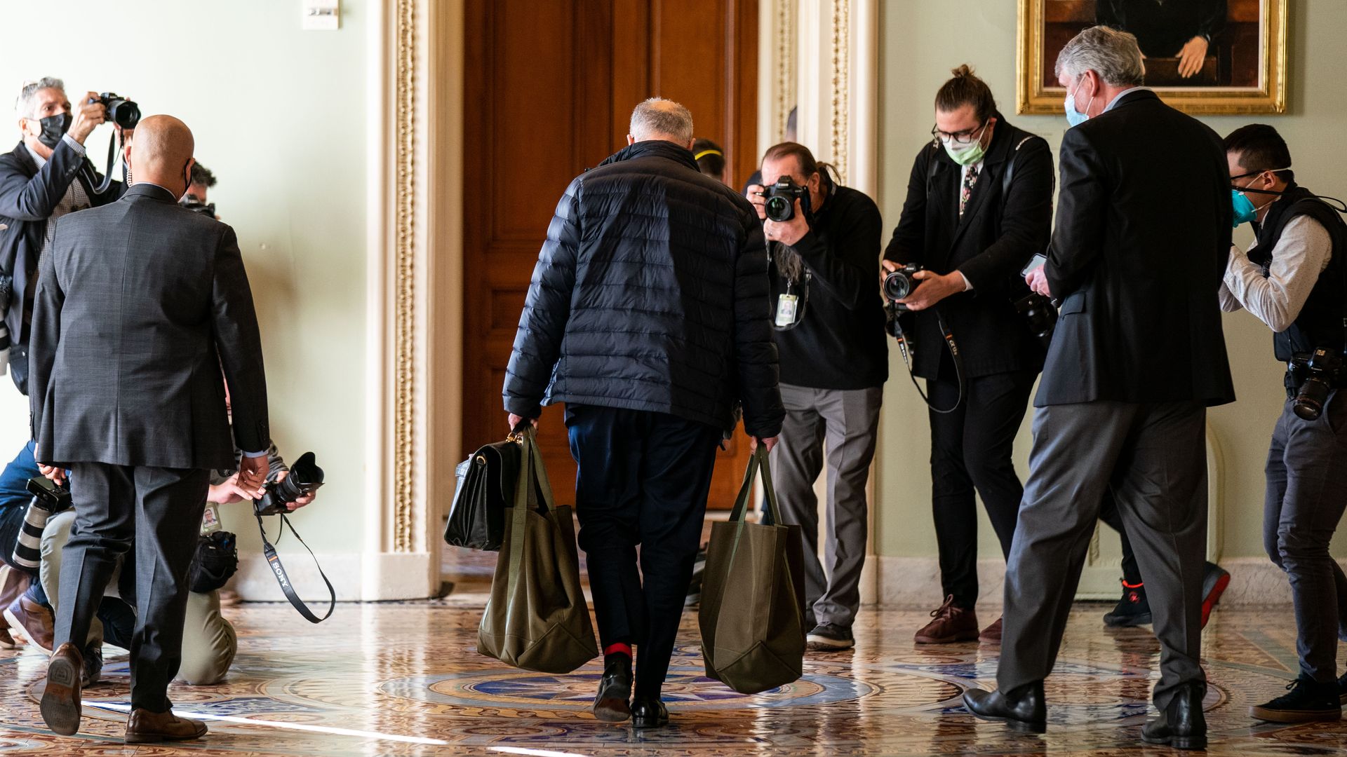 Senate Majority Leader Chuck Schumer is seen surrounded by photographers as he arrives at the Capitol on Monday.