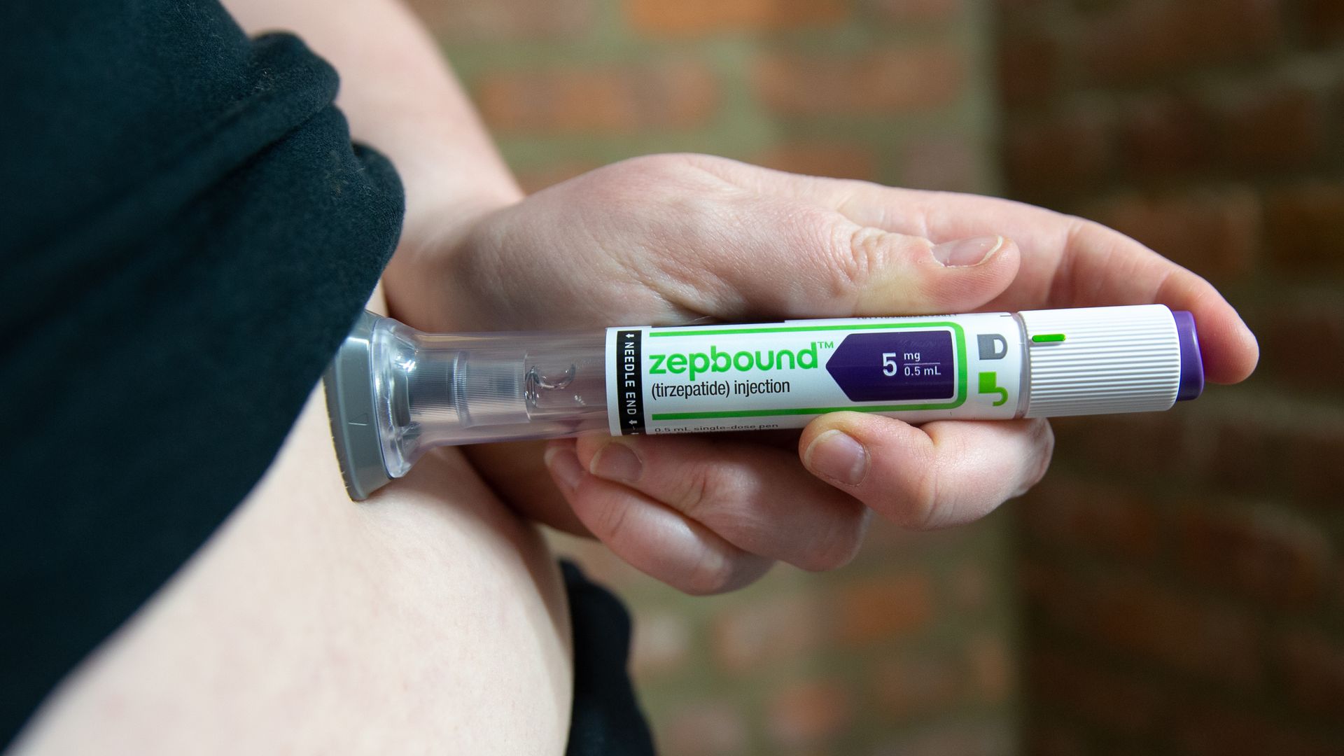 A person gives themselves a shot in the stomach via a Zepbound autoinjector pen