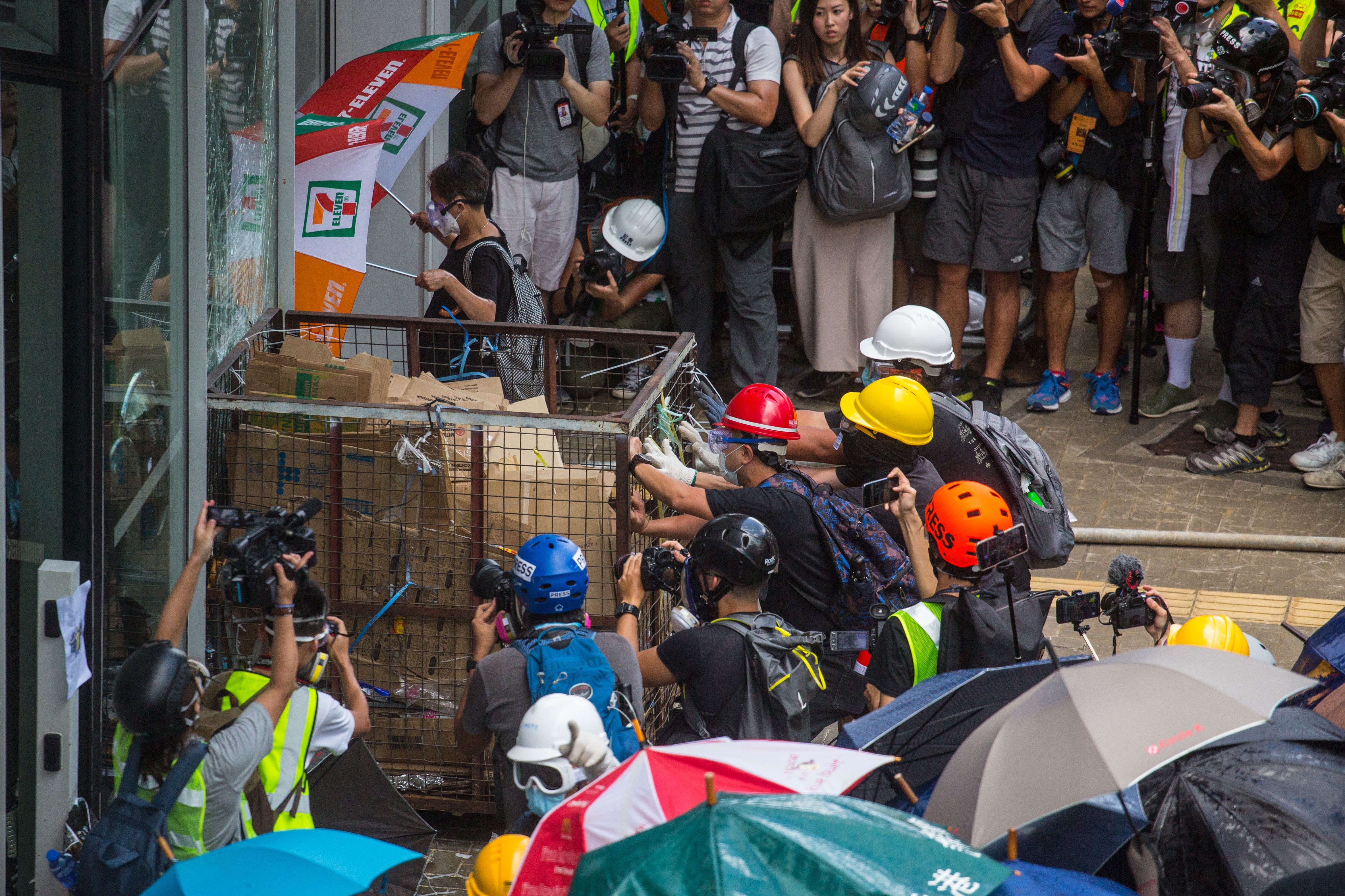  Protesters try to push a metal cart through a closed entrance at the government headquarters in Hong Kong.