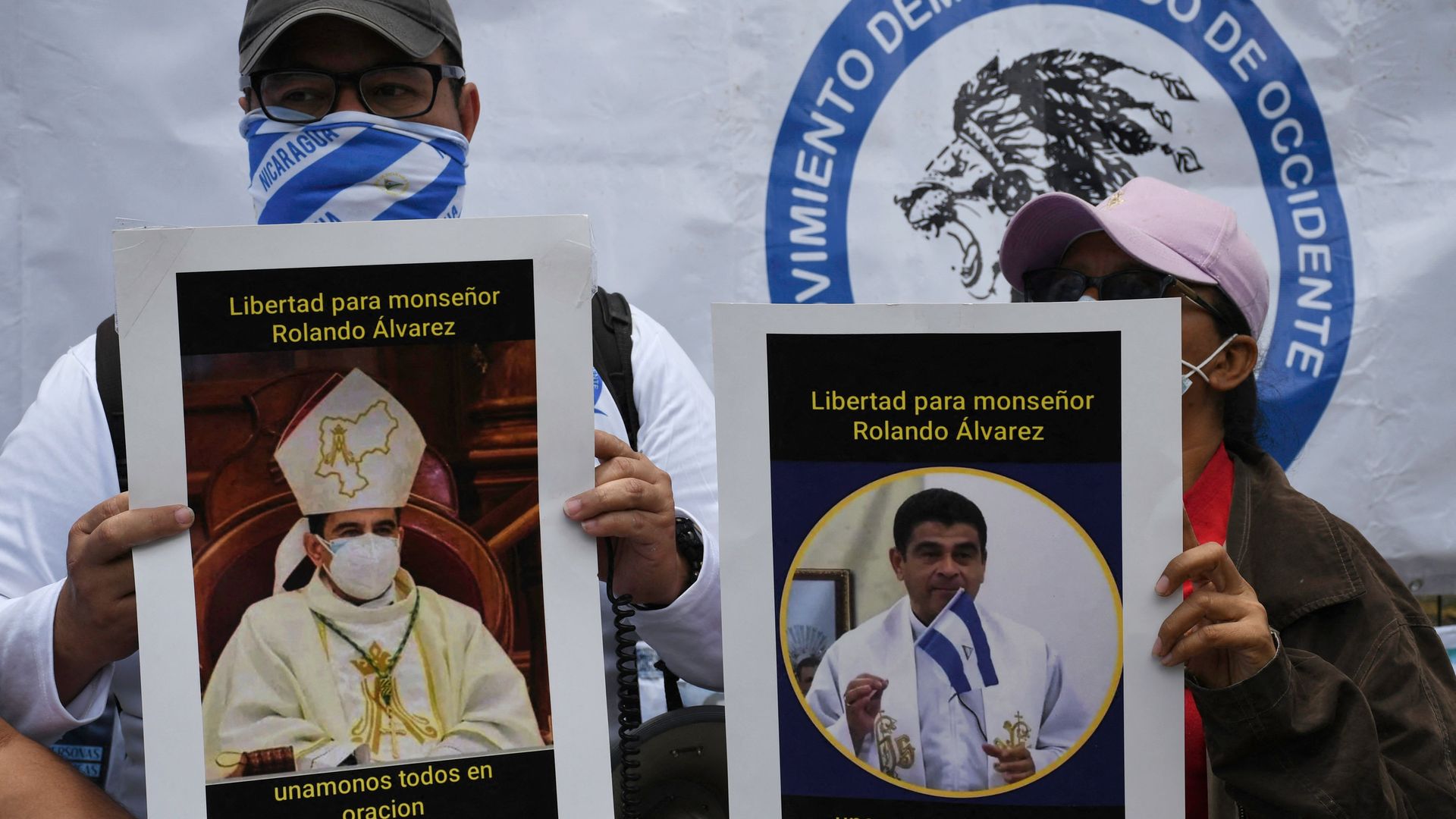 Two protesters hold up posters of Nicaraguan Catholic Bishop Rolando Álvarez while protesting his arrest