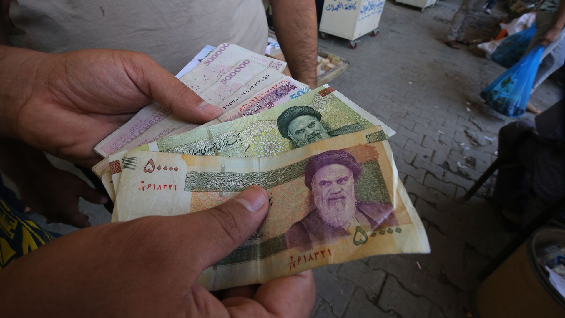 An Iraqi peddler holds in his hand banknotes of Iranian rials for exchange in the Iraqi capital Baghdad. 