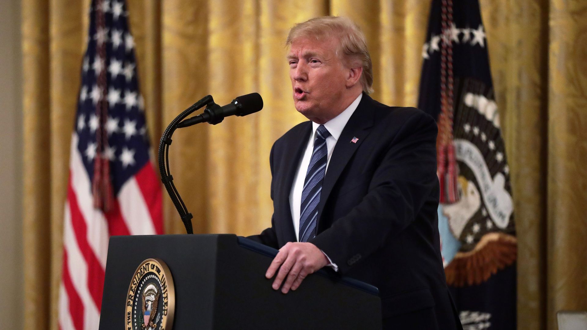 Donald Trump speaks at a podium.