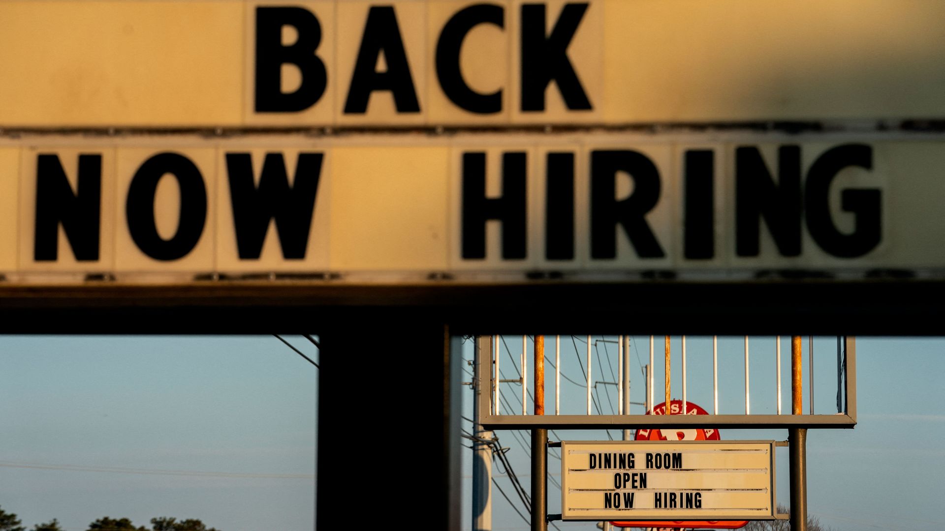Now Hiring signs are displayed in front of restaurants in Rehoboth Beach, Delaware, on March 19, 2022.