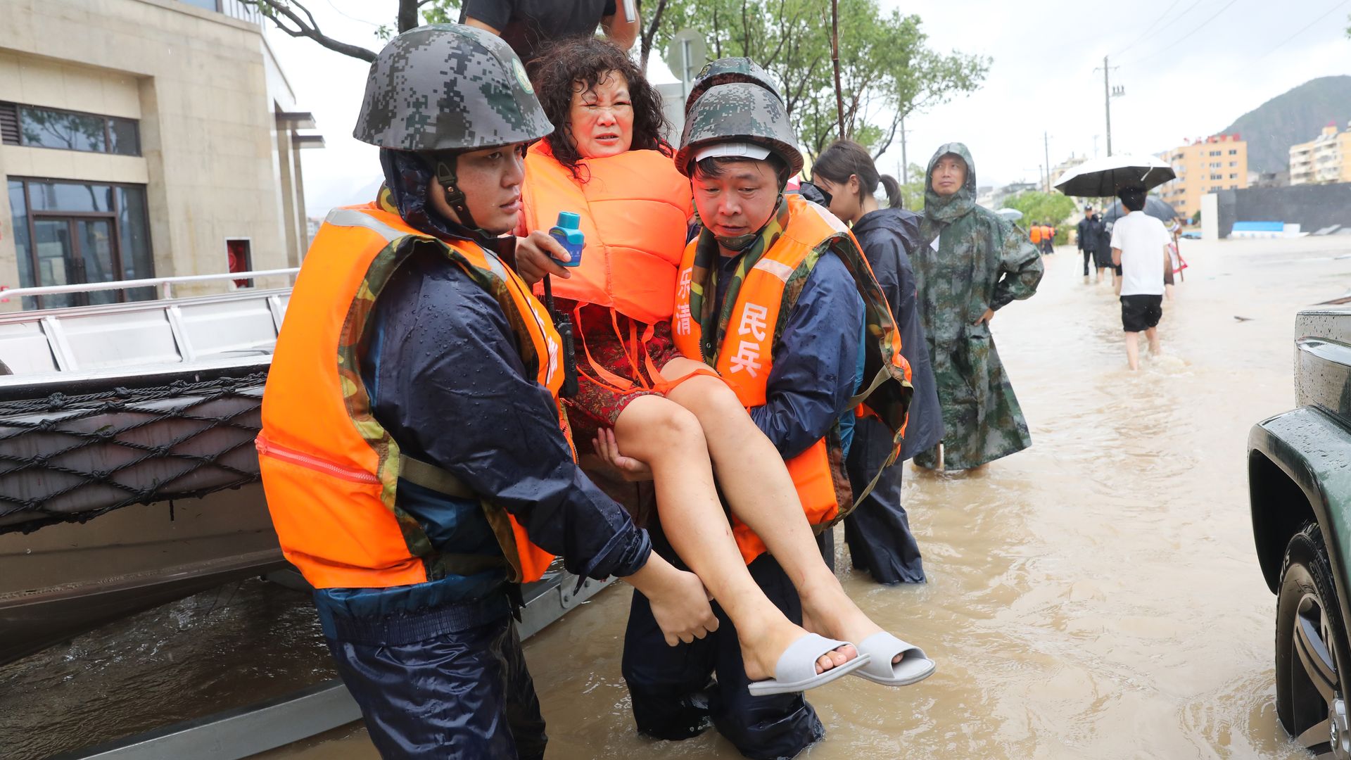 Rescuers evacuate an injured woman as Typhoon Lekima brings heavy rain and strong wind at Dajing Town on August 10