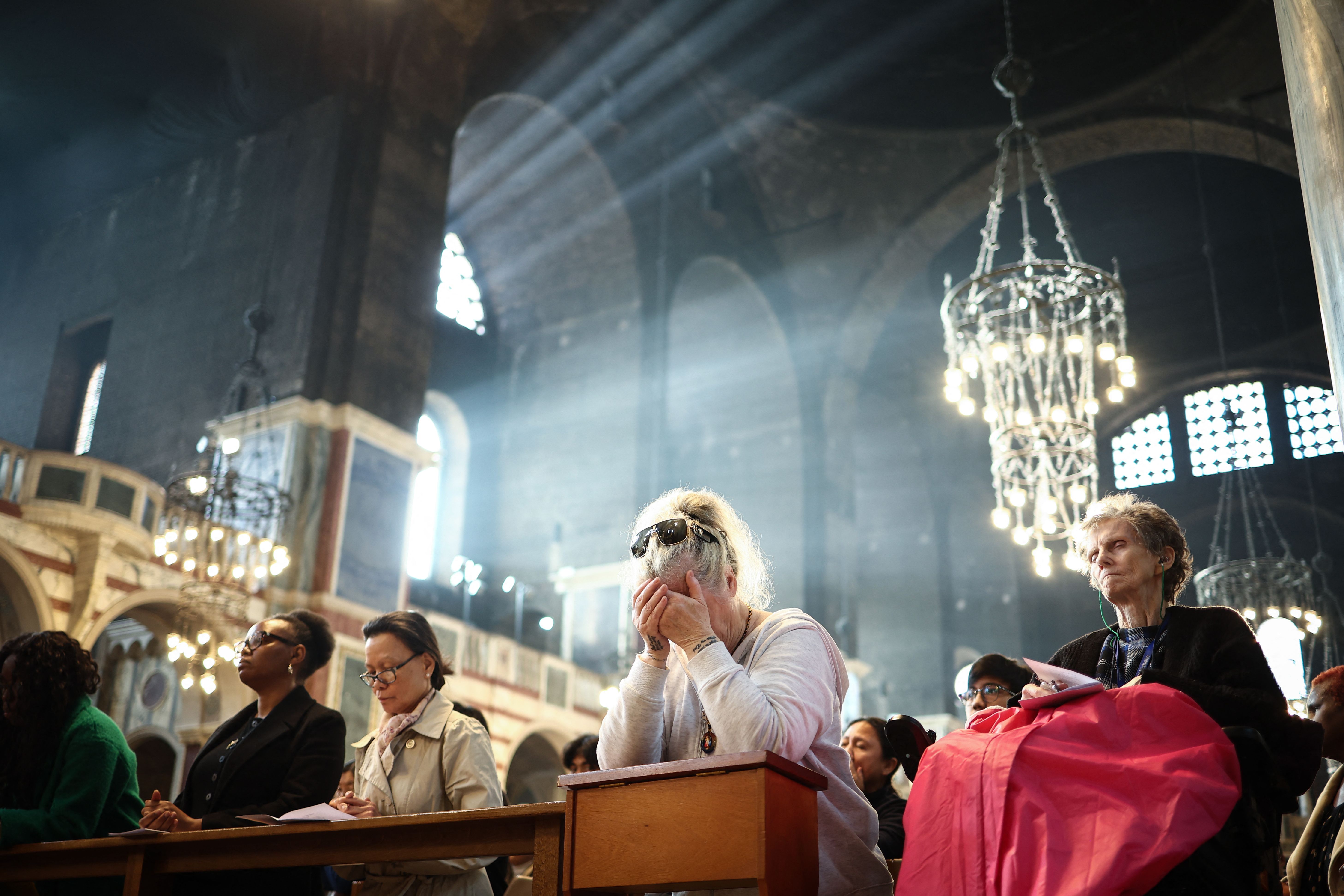 People pray as they attend a solemn requiem at The Metropolitan Cathedral of the Most Precious Blood, informally known as Westminster Cathedral, in central London on April 21, 2025, following the news of the death of Pope Francis. Pope Francis died on April 21, 2025 aged 88, a day after making a muc