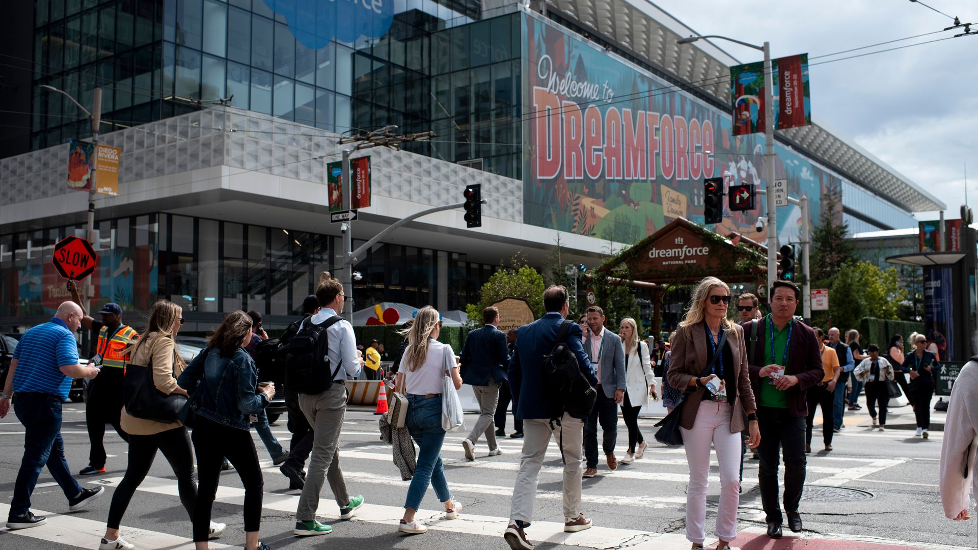 People walking in the streets of SF in front of banner that says "Dreamforce"