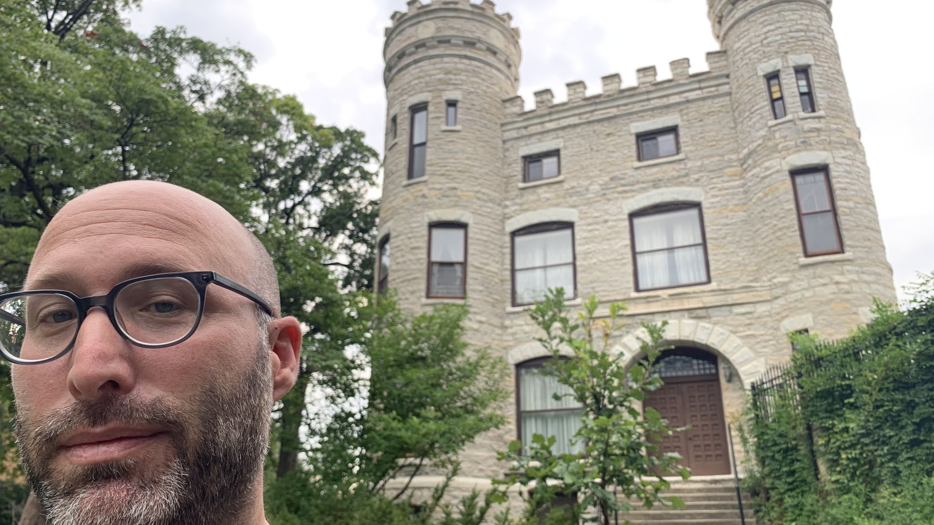 Photo of a man in front of a castle. 