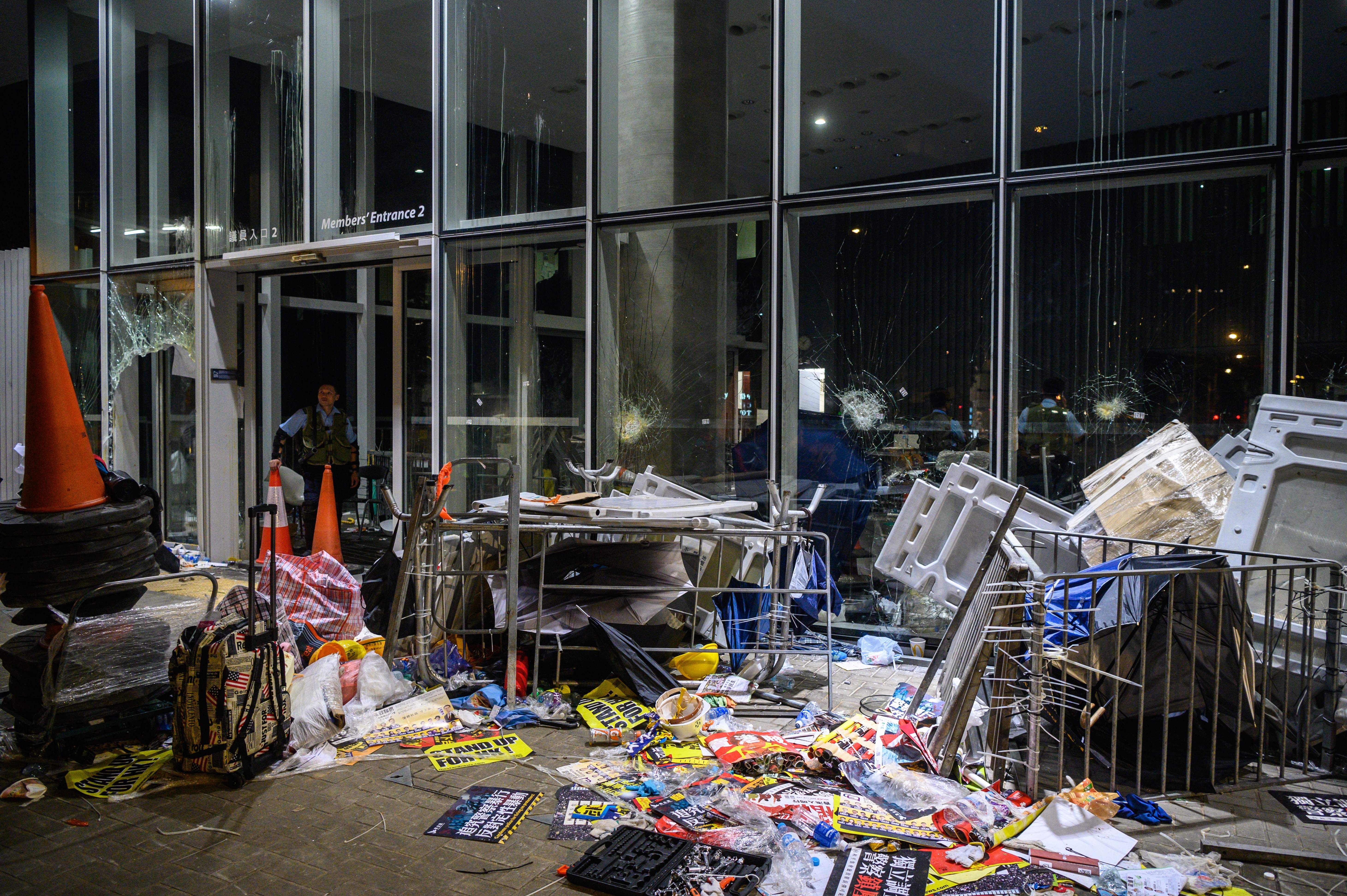A policeman looks at the damage and debris after protesters stormed the government headquarters.