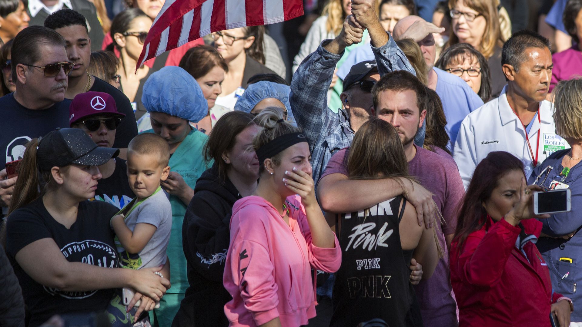 People watch the procession carrying the body of Ventura County Sheriff Sgt. Ron Helus, who was killed in the mass shooting