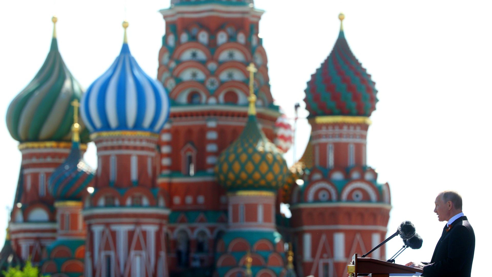 Vladimir Putin speaks at a podium standing before the Red Square.