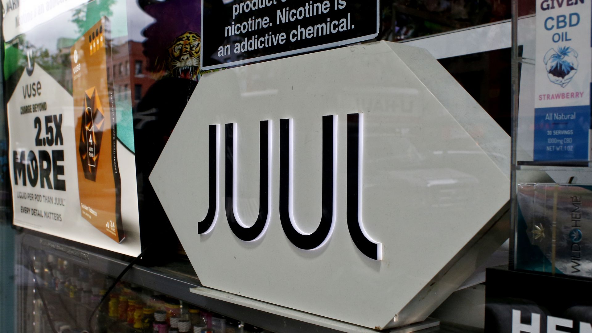 A Juul add is seen while a person is reflected at smoke shop on June 23, 2022 in New York.