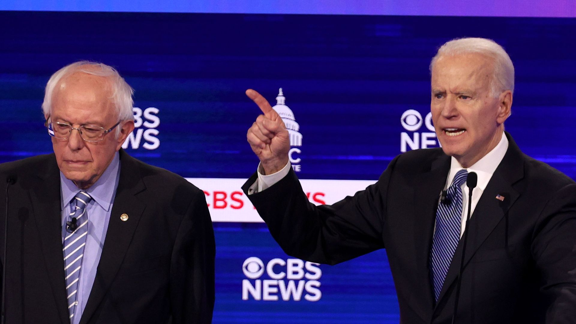 Joe Biden gesturing during a Democratic debate, with Bernie Sanders to his right