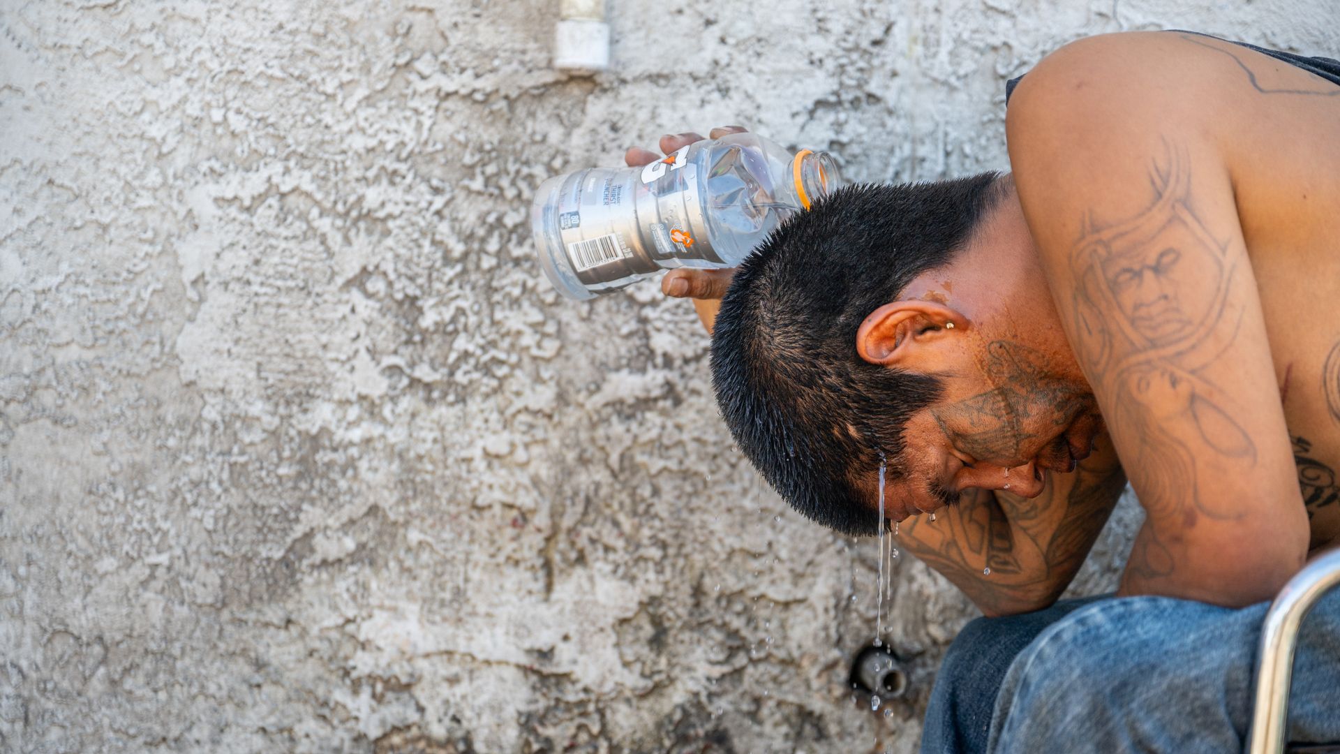 A man pouring water over his head.