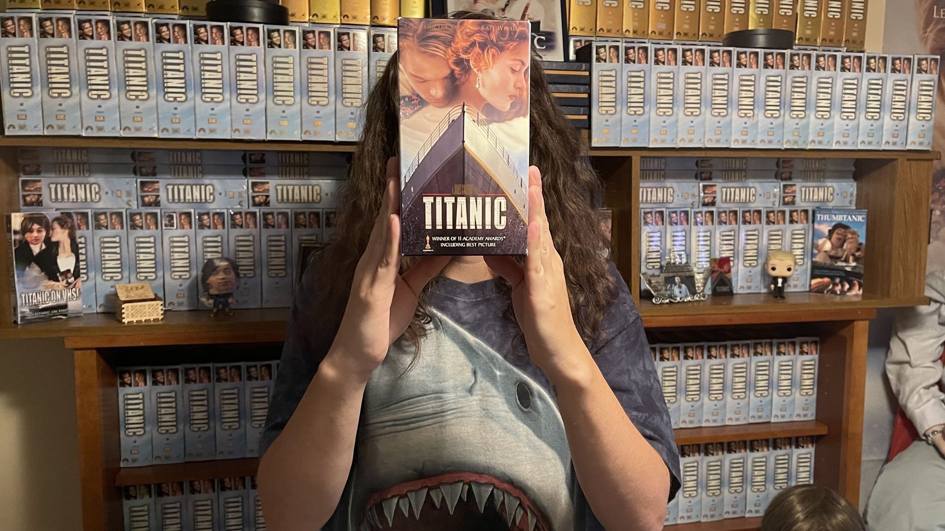 @titanicfan97 with his collection, holding a copy of "Titanic" on VHS in front of his face