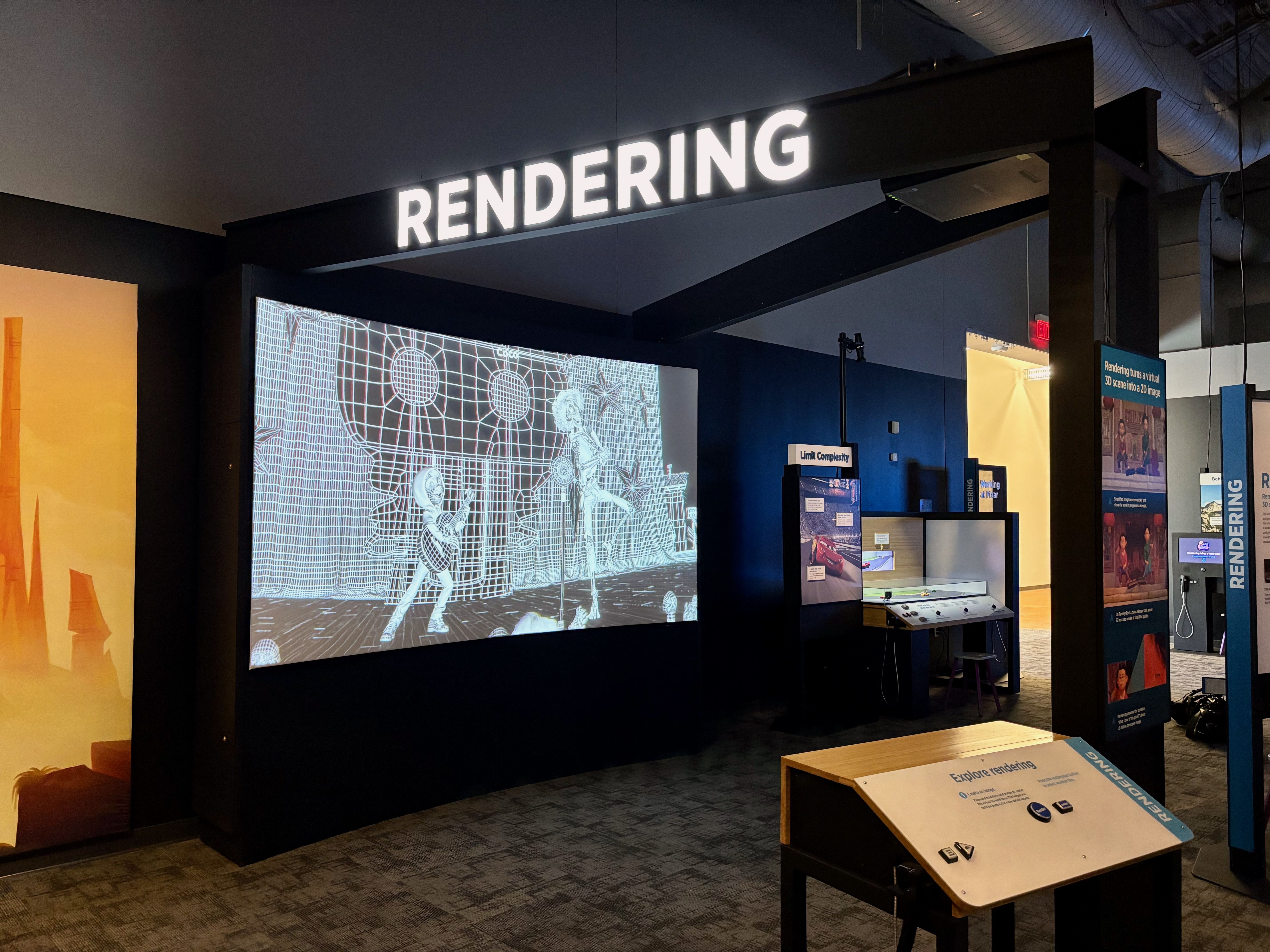 Dark exhibition space with a bright "RENDERING" sign, showing a projection of wireframe animation from "Coco" and nearby informational displays about rendering in 3D.
