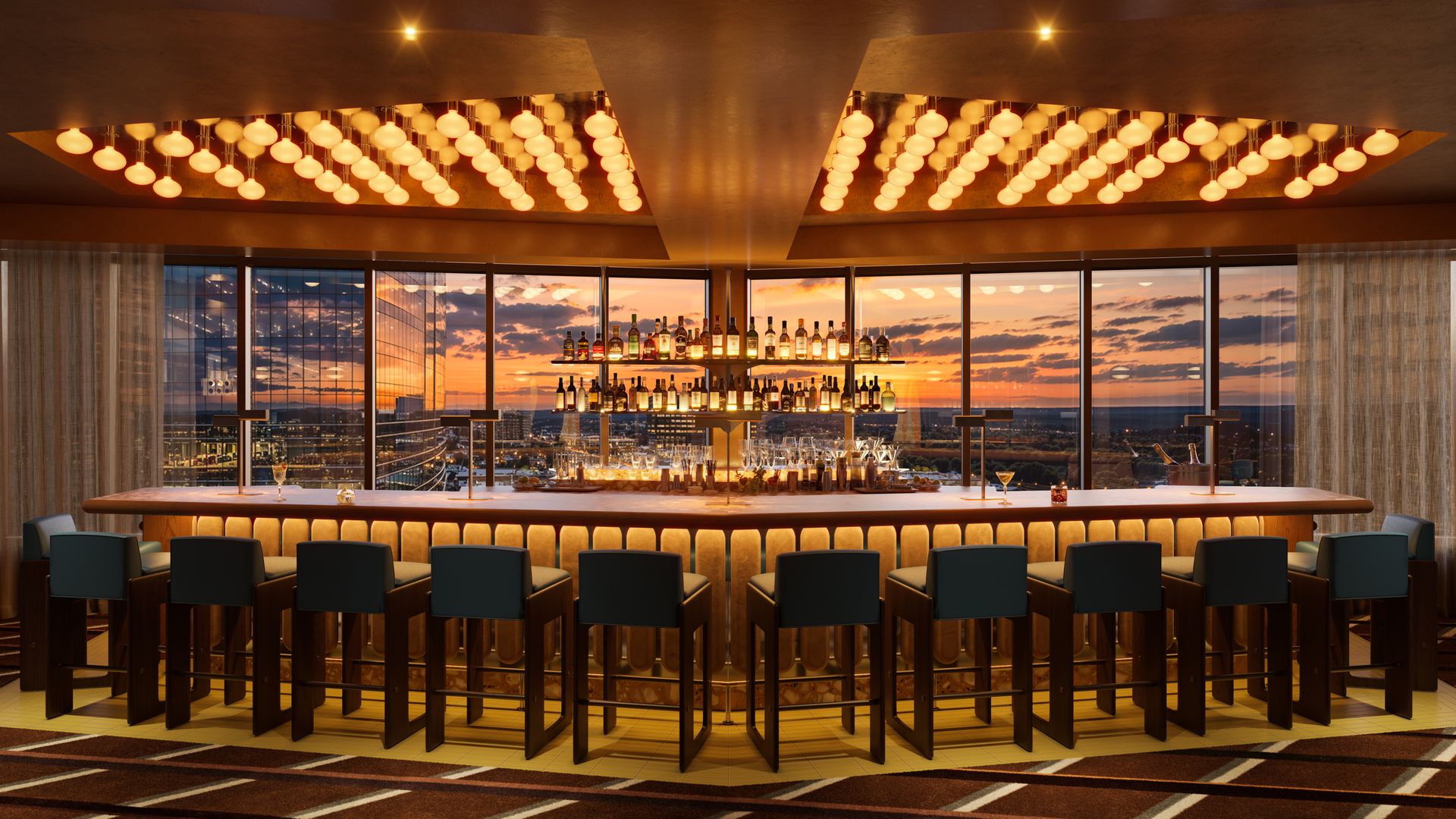 Chic rooftop bar with a long wooden counter, teal stools, and liquor shelves. Warm globe lights illuminate the space as sunset and a city skyline glow through large glass windows.