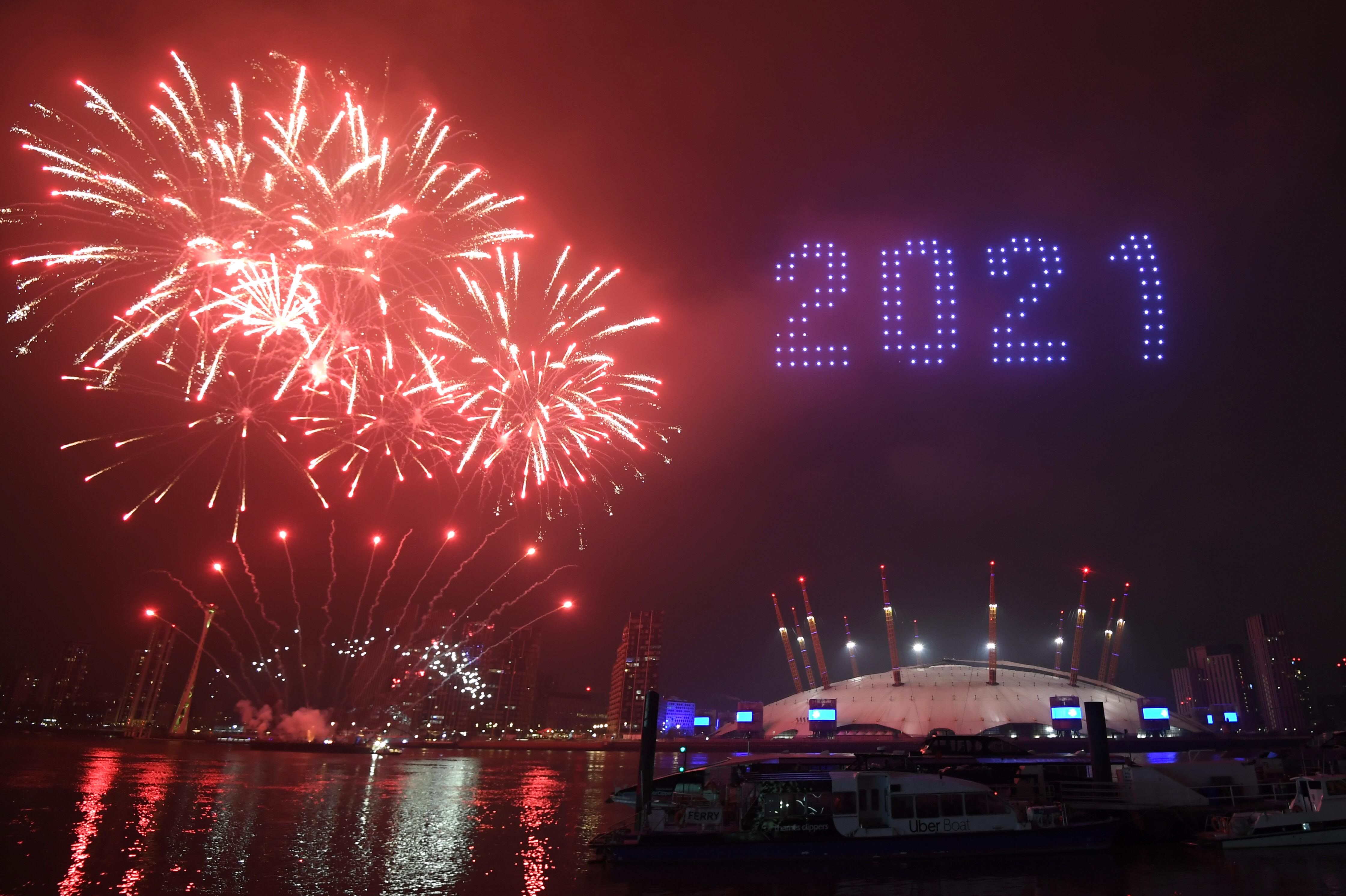 Fireworks and drones illuminate the night sky over the The O2 in London as they form a light display as London's normal New Year's Eve fireworks display was cancelled due to the coronavirus pandemic