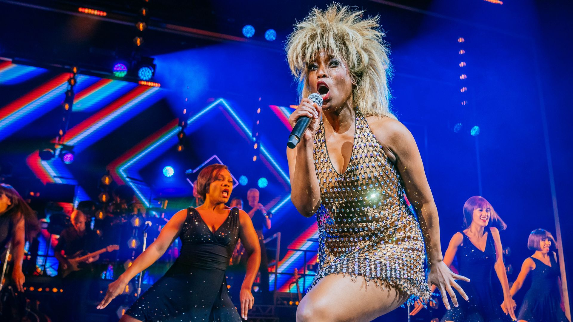A performers costumed as Tina Turner dances and sings in Tina: The Tina Turner Musical. 