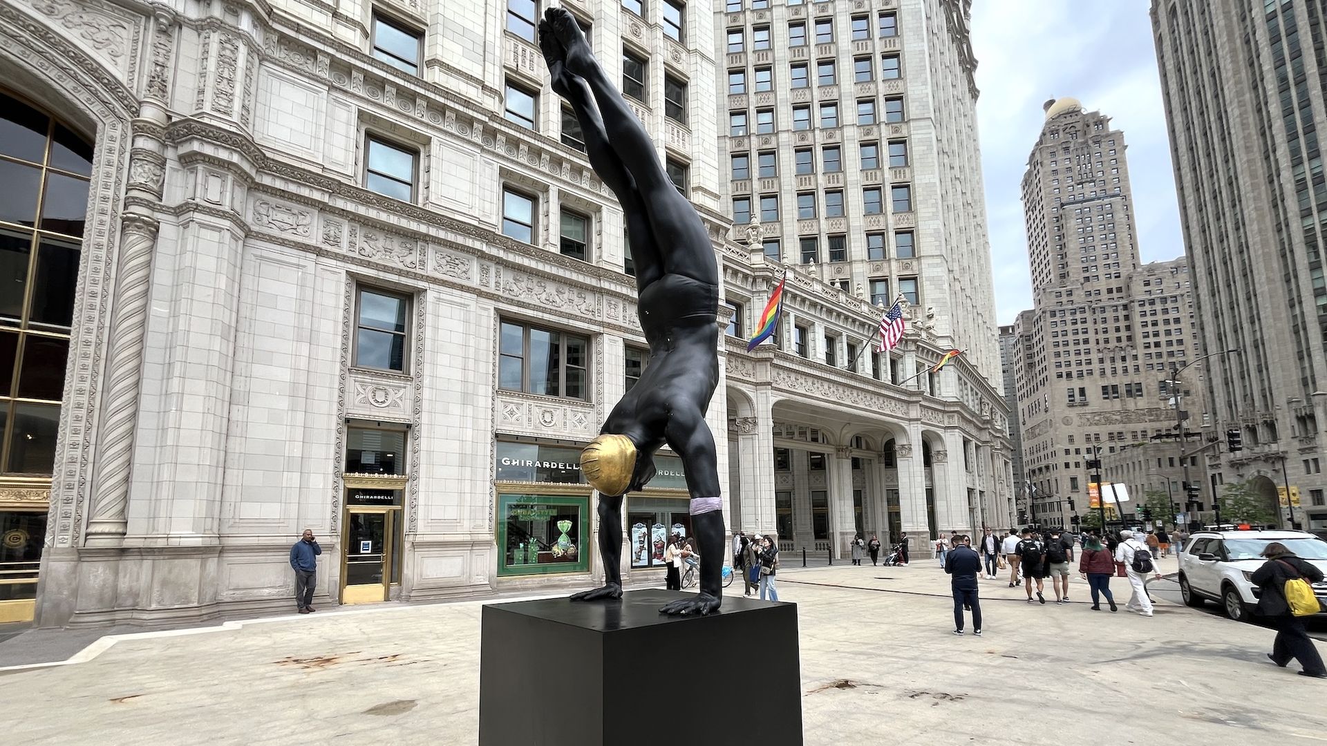 Black sculpture of person diving, wearing a gold swim cap