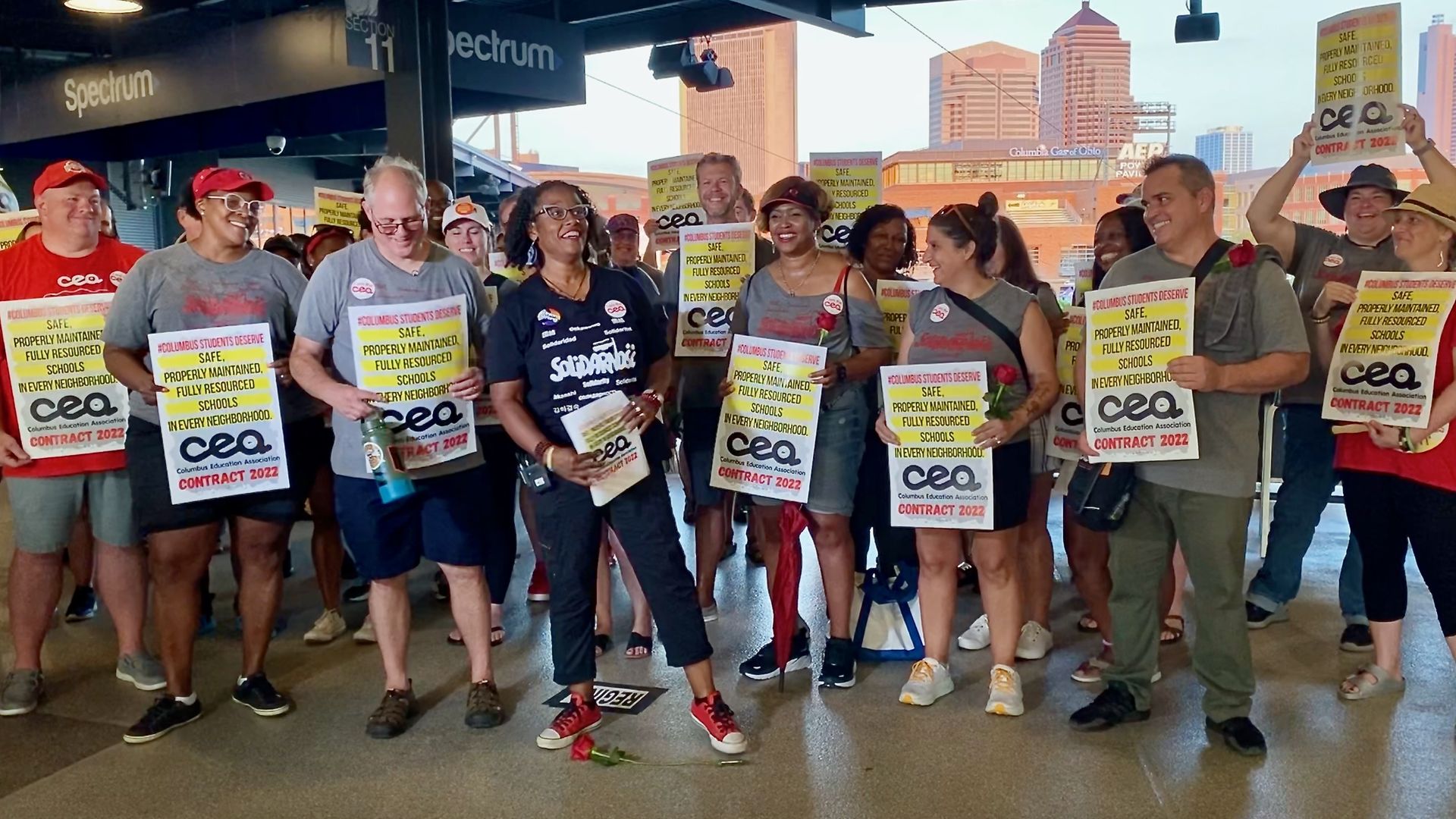 Columbus Education Association leadership holds signs reading "#ColumbusStudentsDeserve safe, properly maintained, fully resourced schools in every neighborhood, CEA contract 2022"