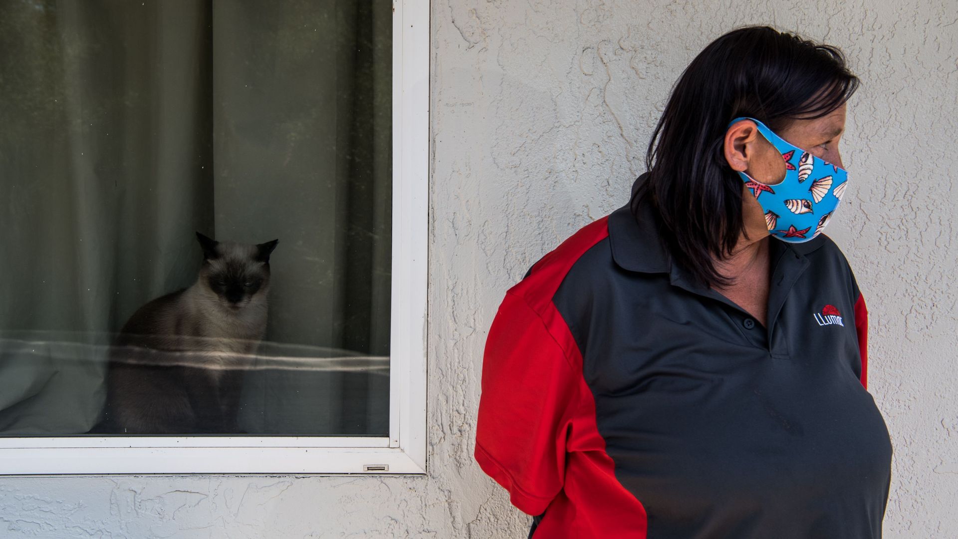 A woman looks on as the head of the Kissimmee-Poinciana Homeless Outreach donates essentials to jobless people living in a motel in Kissimmee, Florida. Photo: Chandan Khanna/AFP via Getty Images