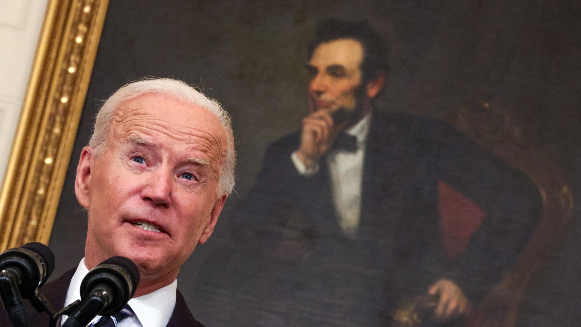 President Biden's face is shown close up, with Abraham Lincoln's portrait in the background