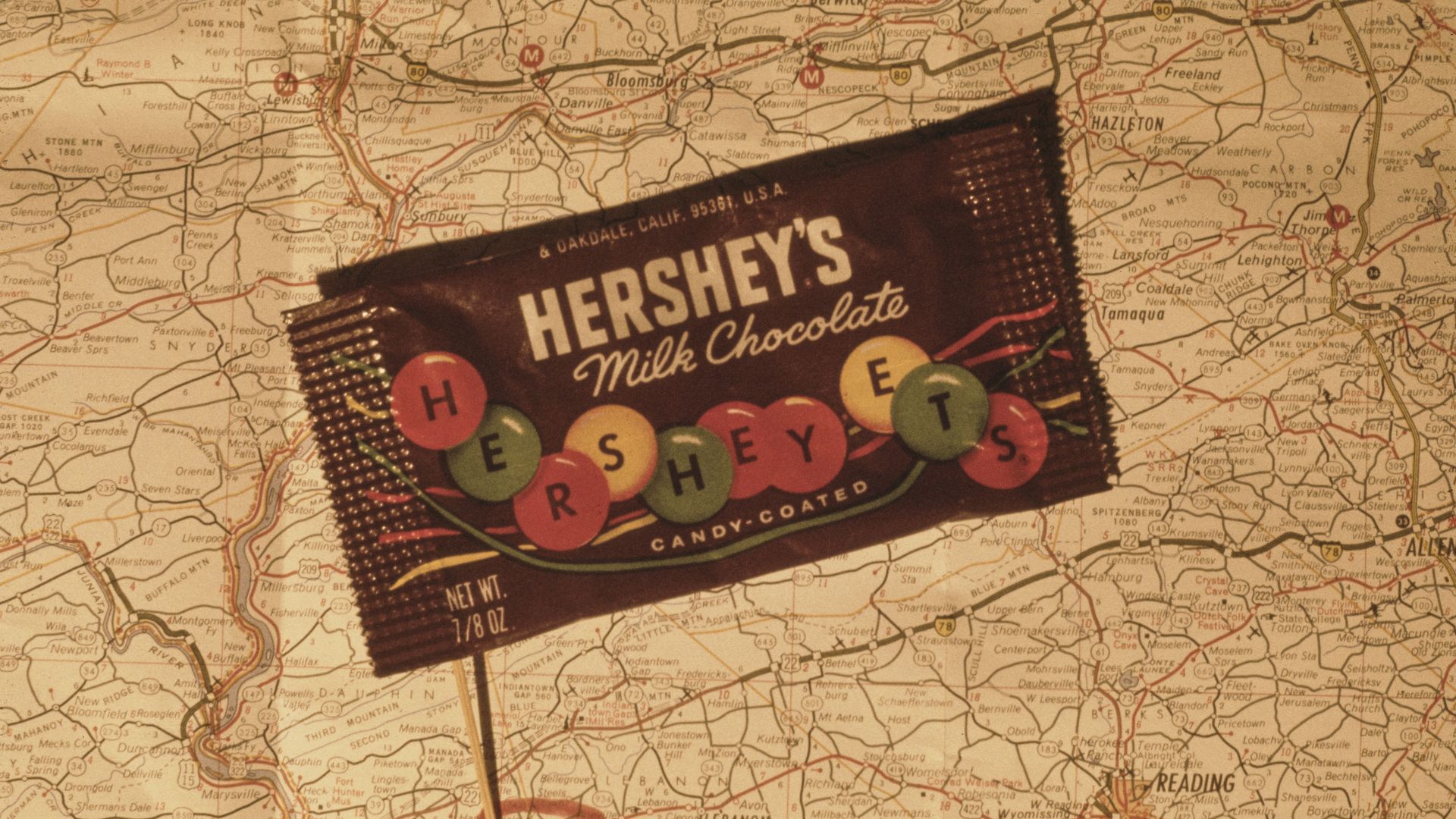 A packet of candy-coated Hershey's milk chocolate on a map of Pennsylvania, showing the location of the original Hershey chocolate factory in Hershey, Derry Township, USA, just east of Harrisburg, November 1969.