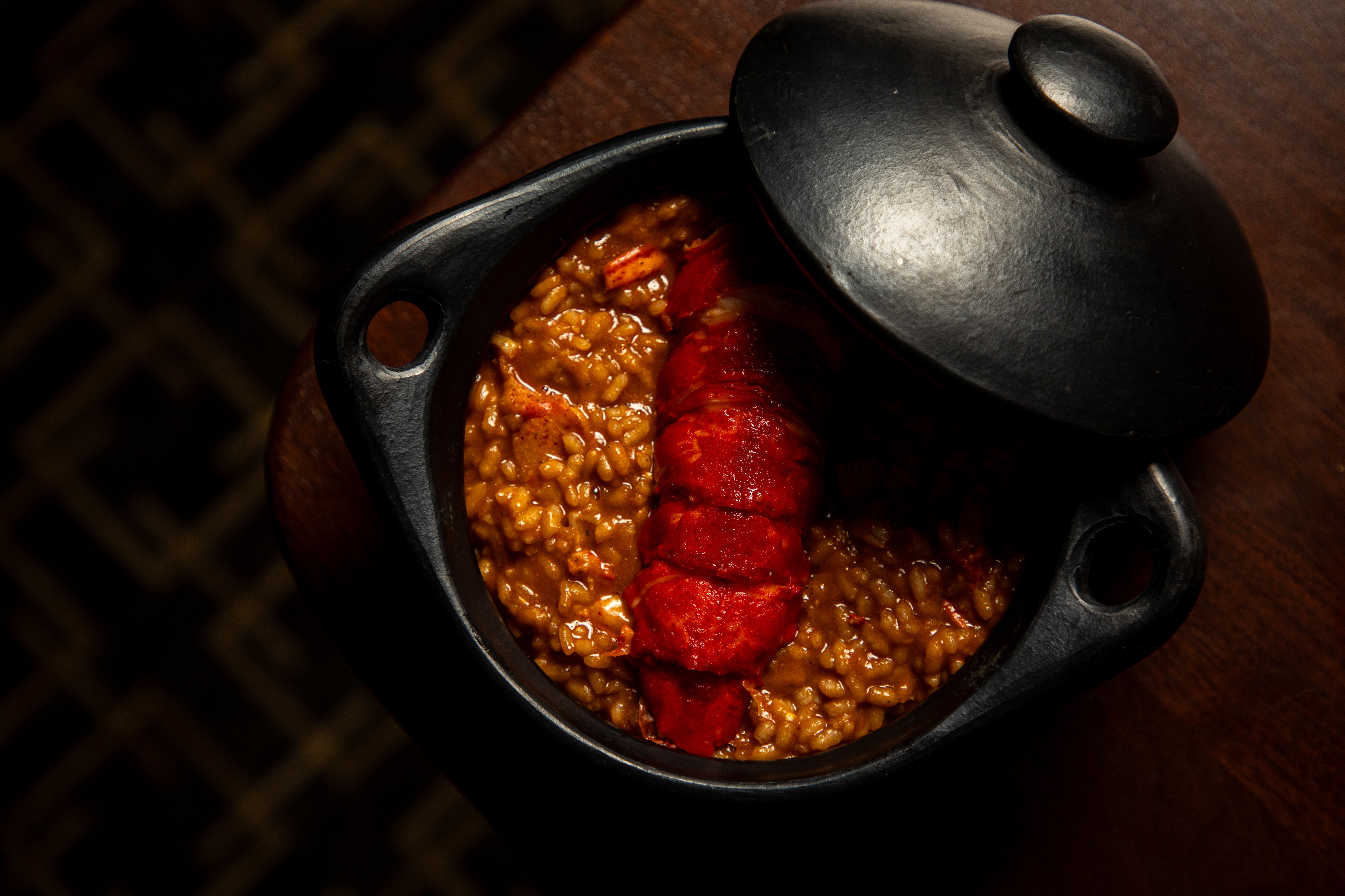 A small black pot is filled with a rice dish.