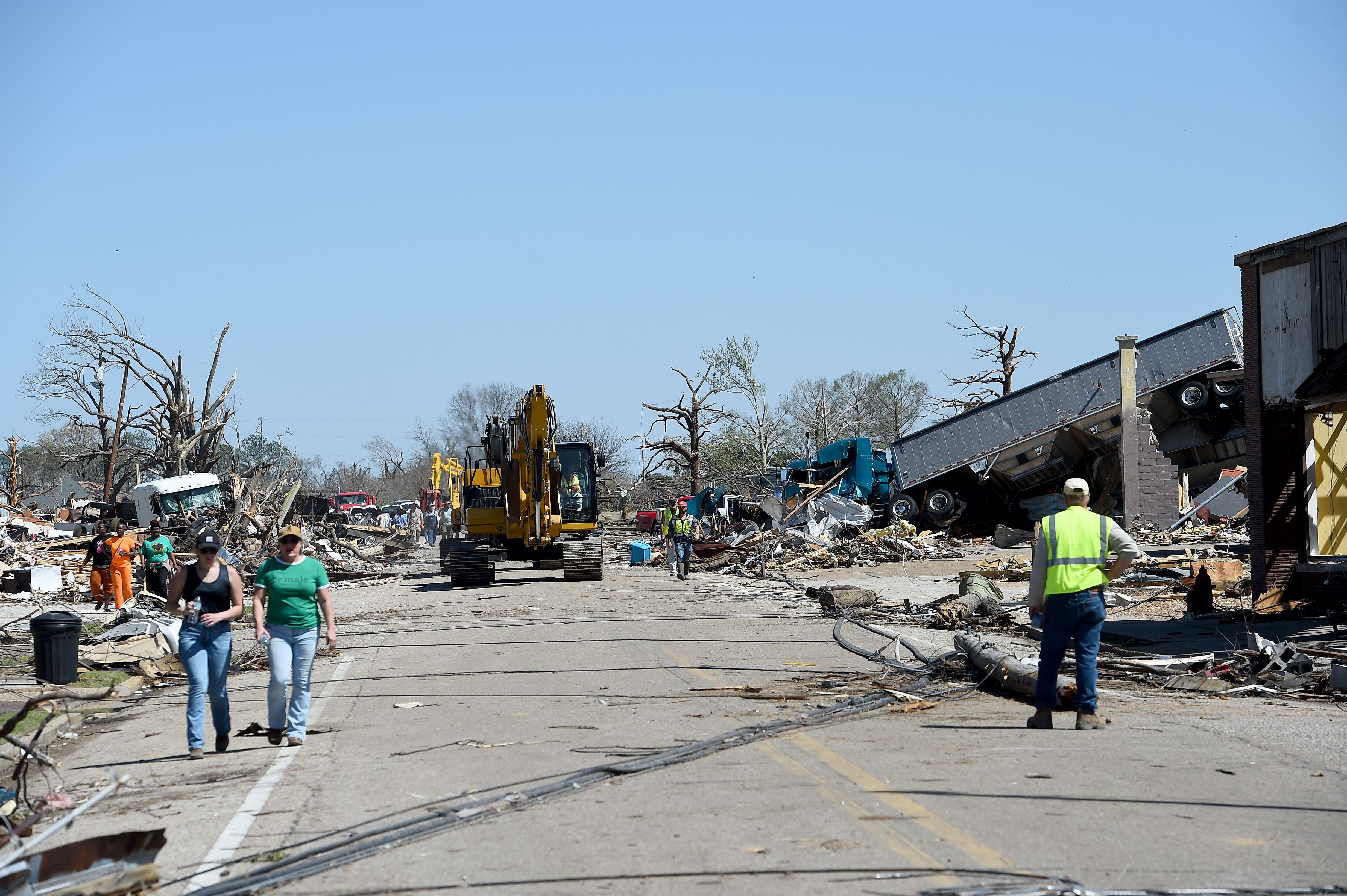 Tornado damage to infrastructure and people walking.