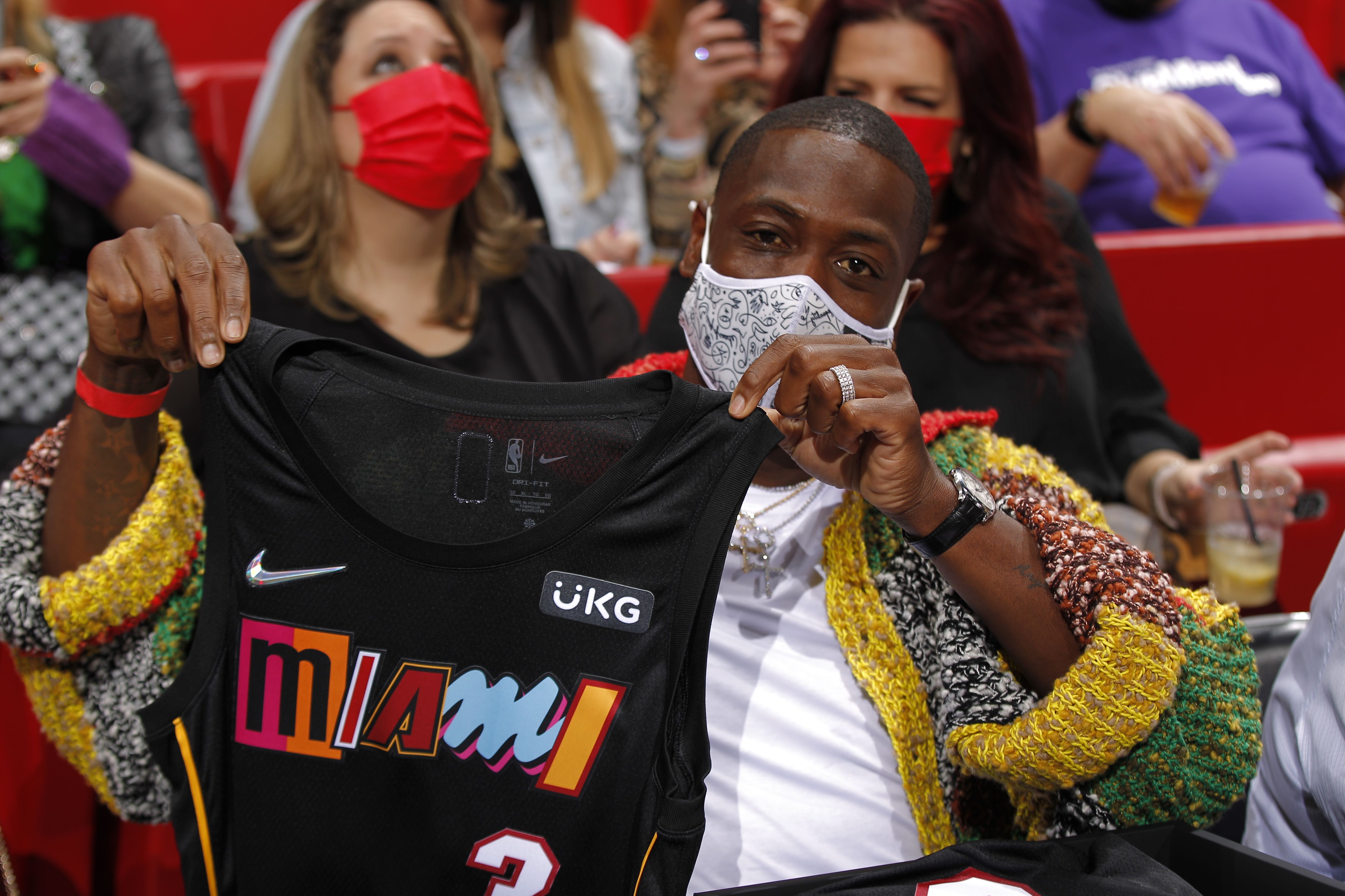 Miami Heat legend Dwyane Wade shows off the Heat's black Mashup jerseys (with "Miami" lettering on the front in varied styles from previous Heat jersey designs)