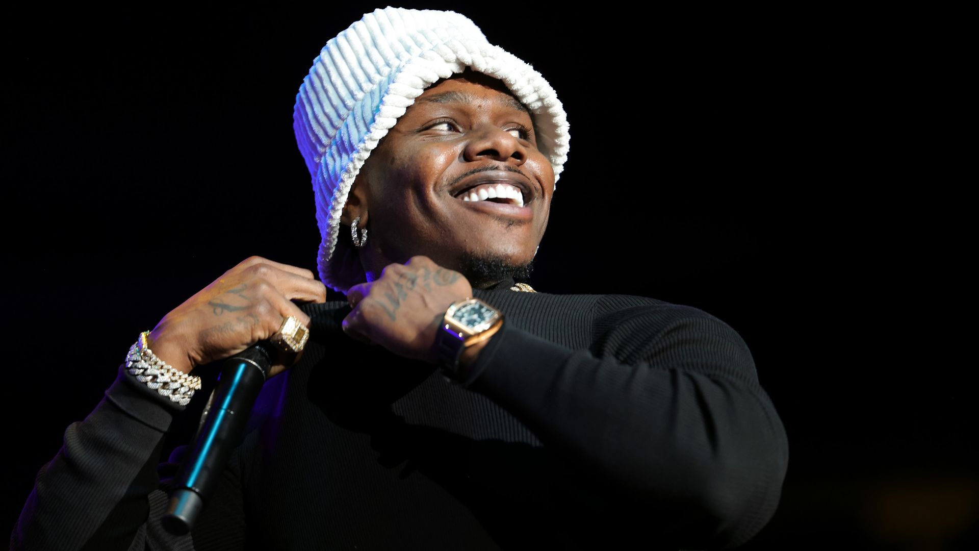 DaBaby smiles with a mic in his hand