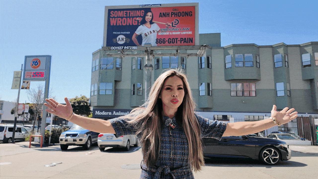 Gif showing Anh Phoong pointing to a billboard with her image in an exuberant nature
