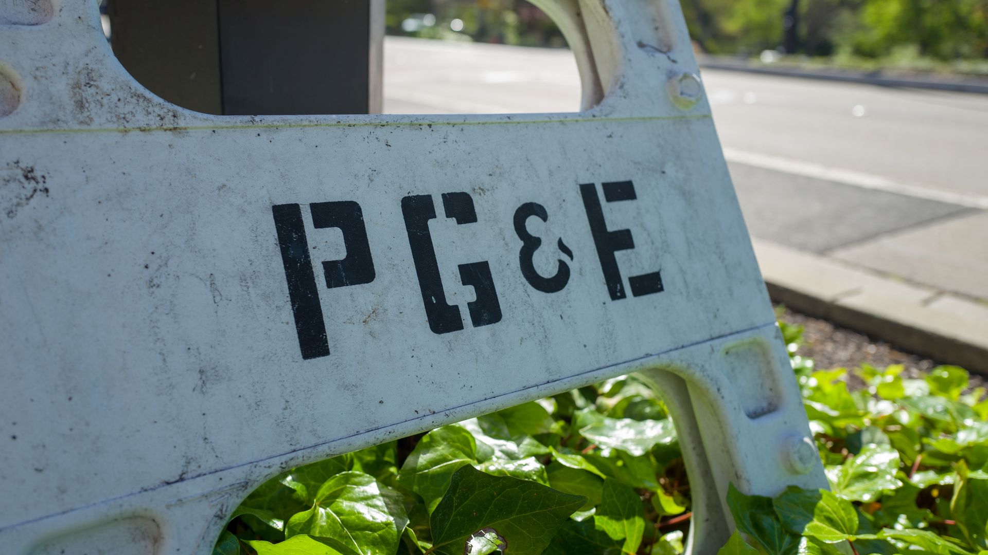 Close-up of road marker with stenciled text reading PG&E
