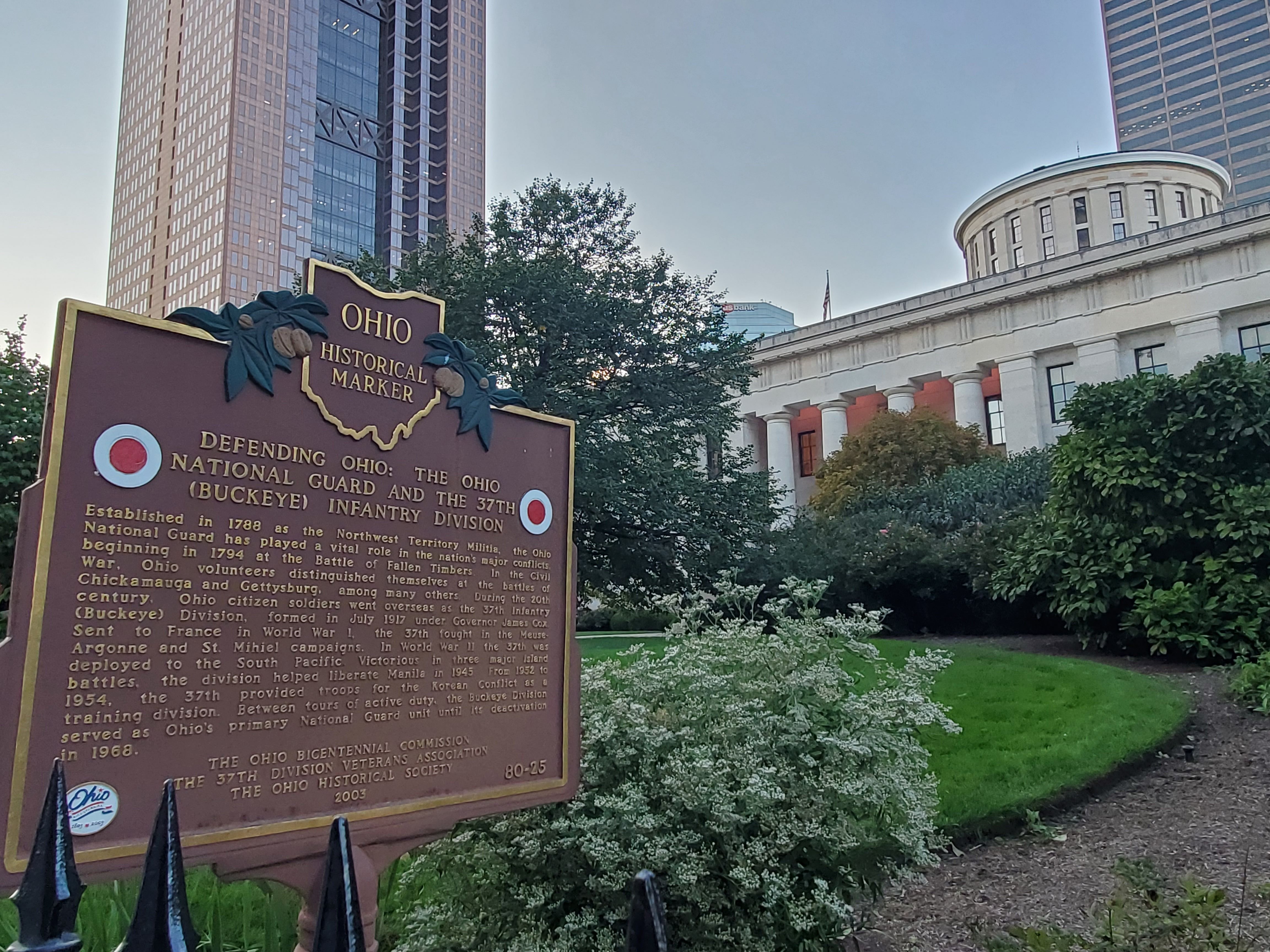 The back side of a historical marker detailing Ohio's role in the Civil War, with the Ohio Statehouse in the background