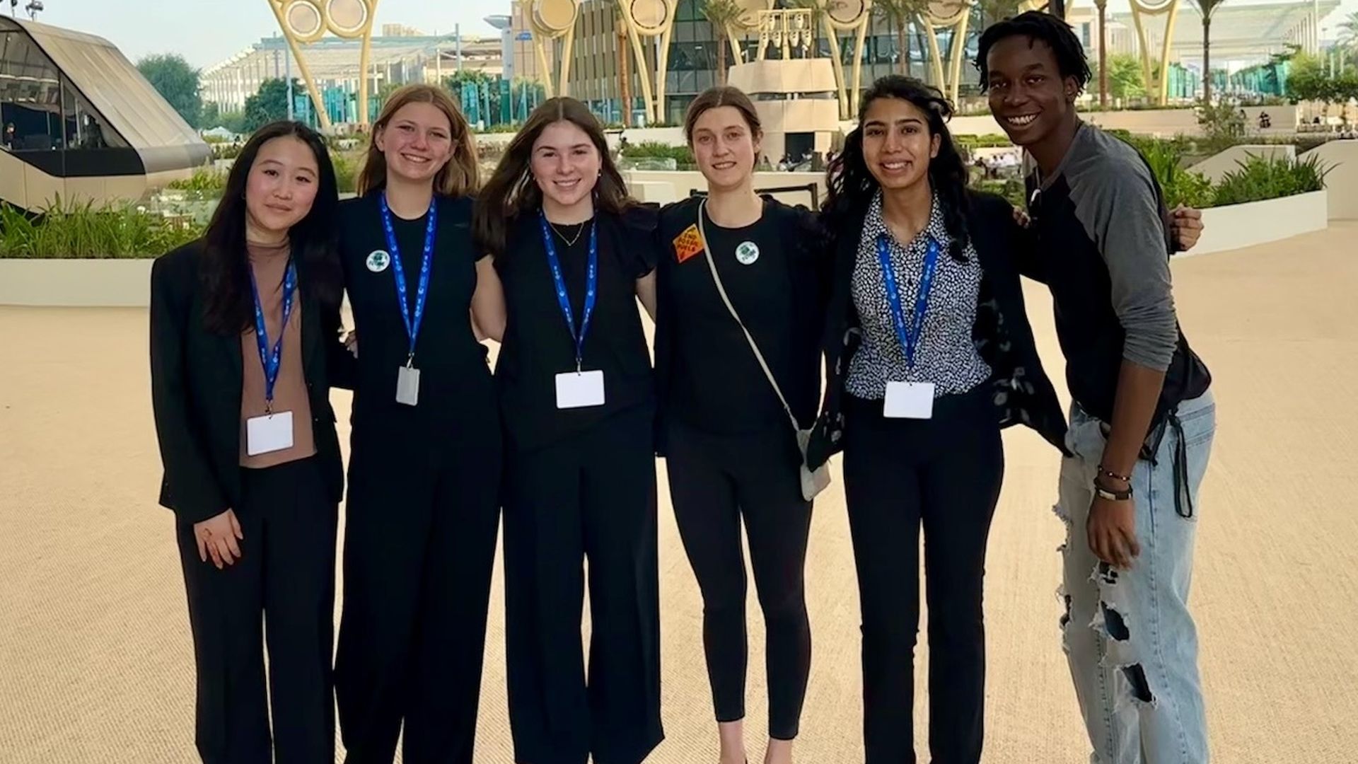 Five high school students smile at the camera while wearing business clothes.