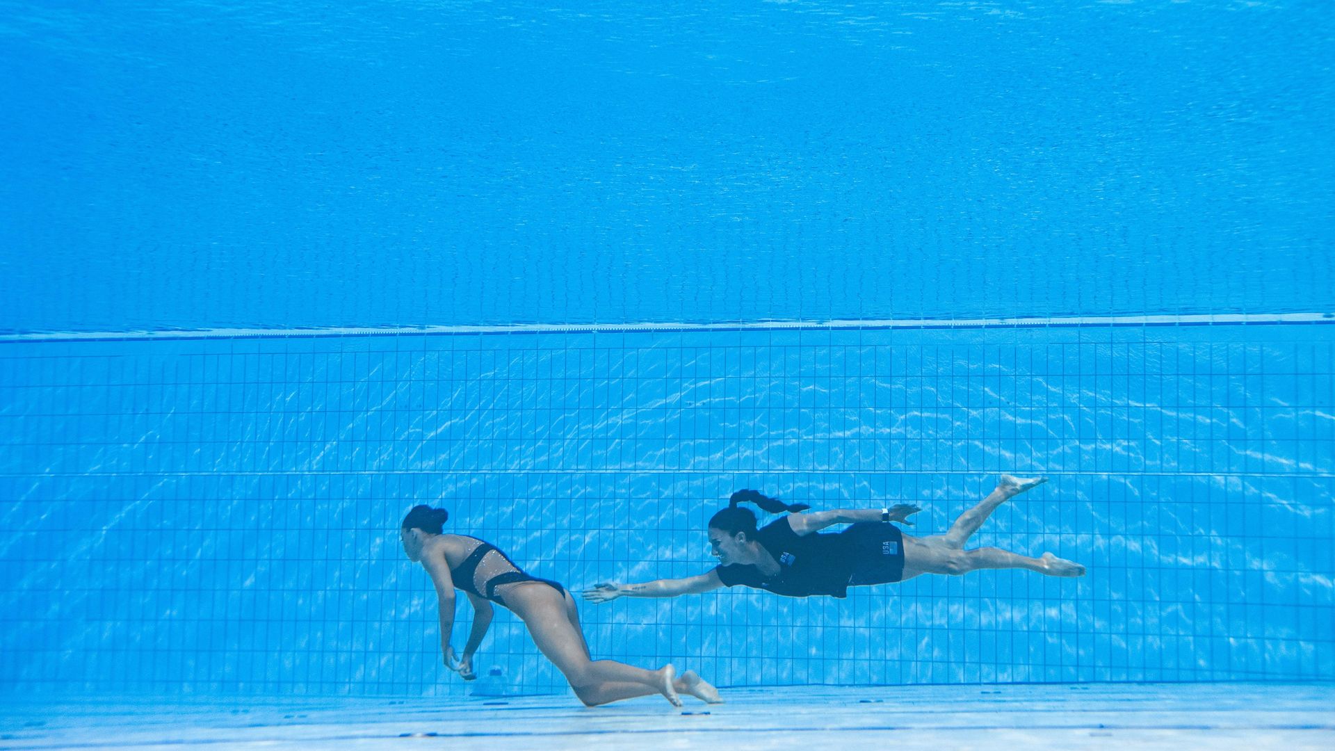Fuentes swimming toward Alvarez as she sank to the bottom of the pool.