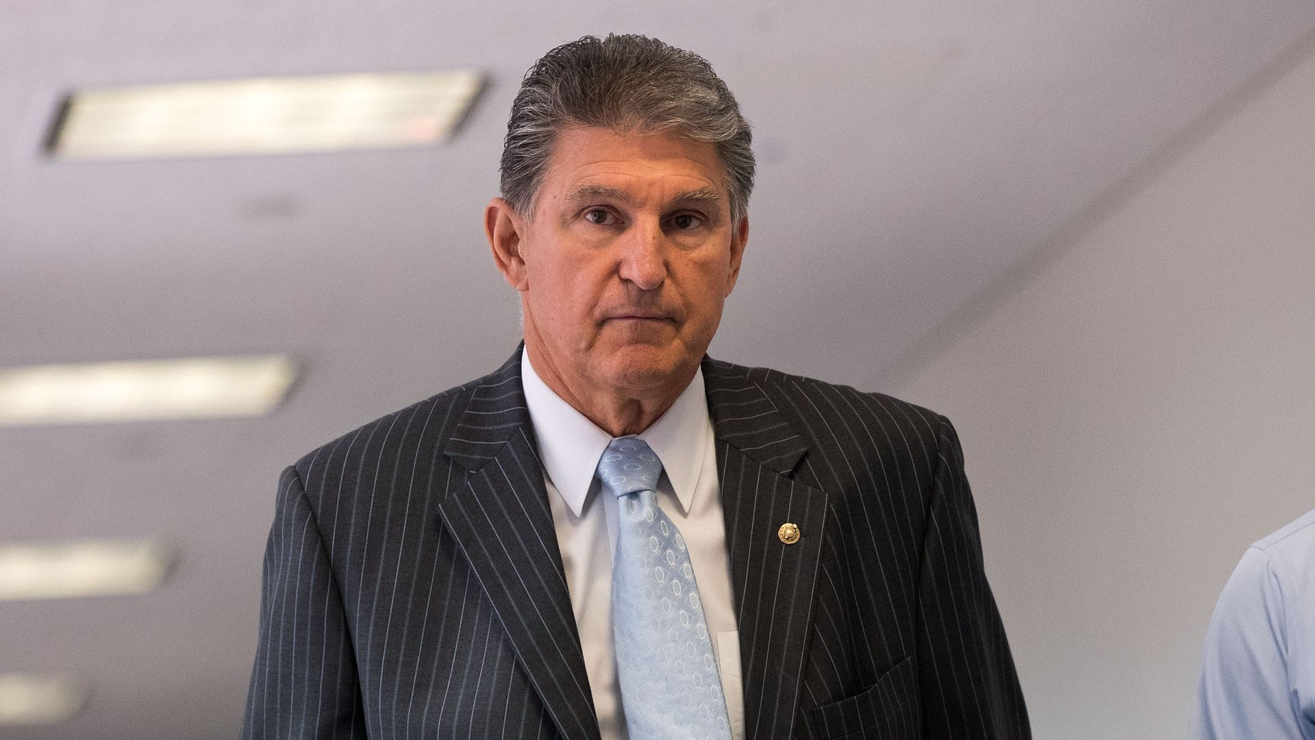 Sen. Manchin walks down a corridor 