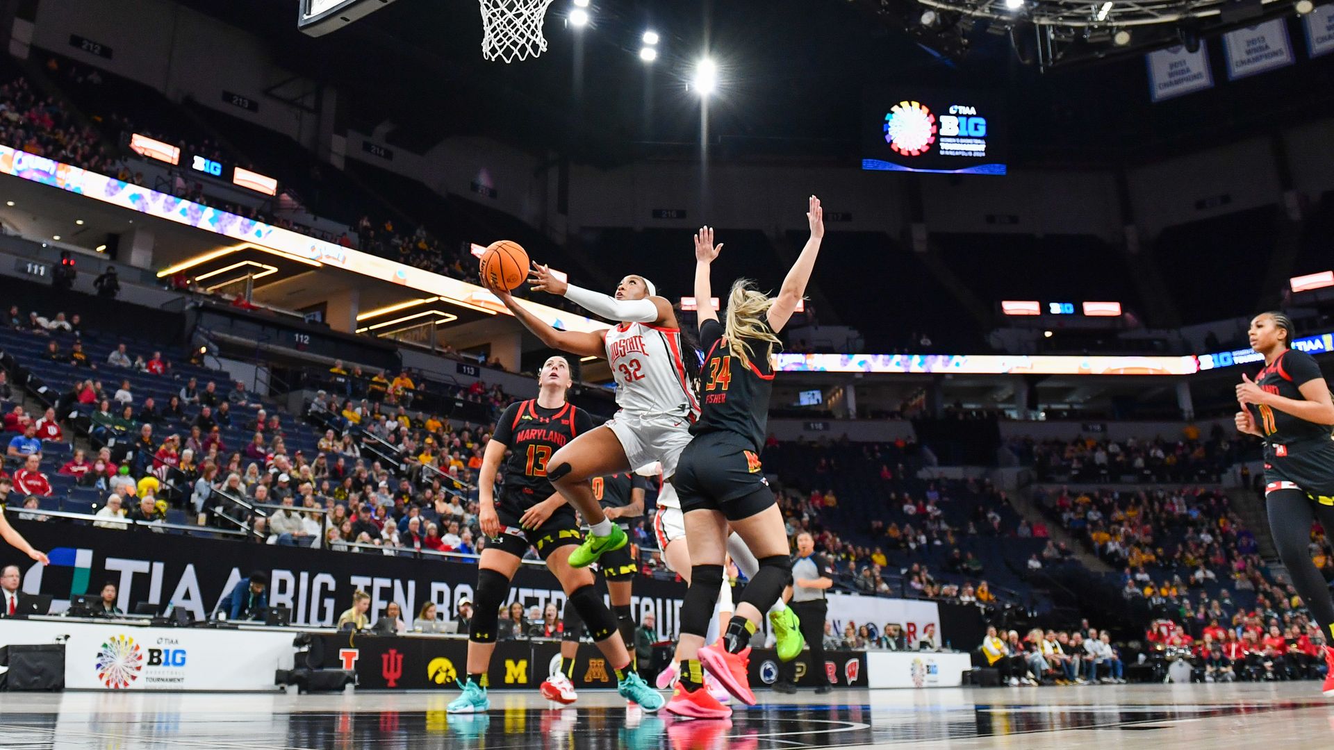 Photo of Ohio State women's basketball player driving for a layup against Maryland defenders. 