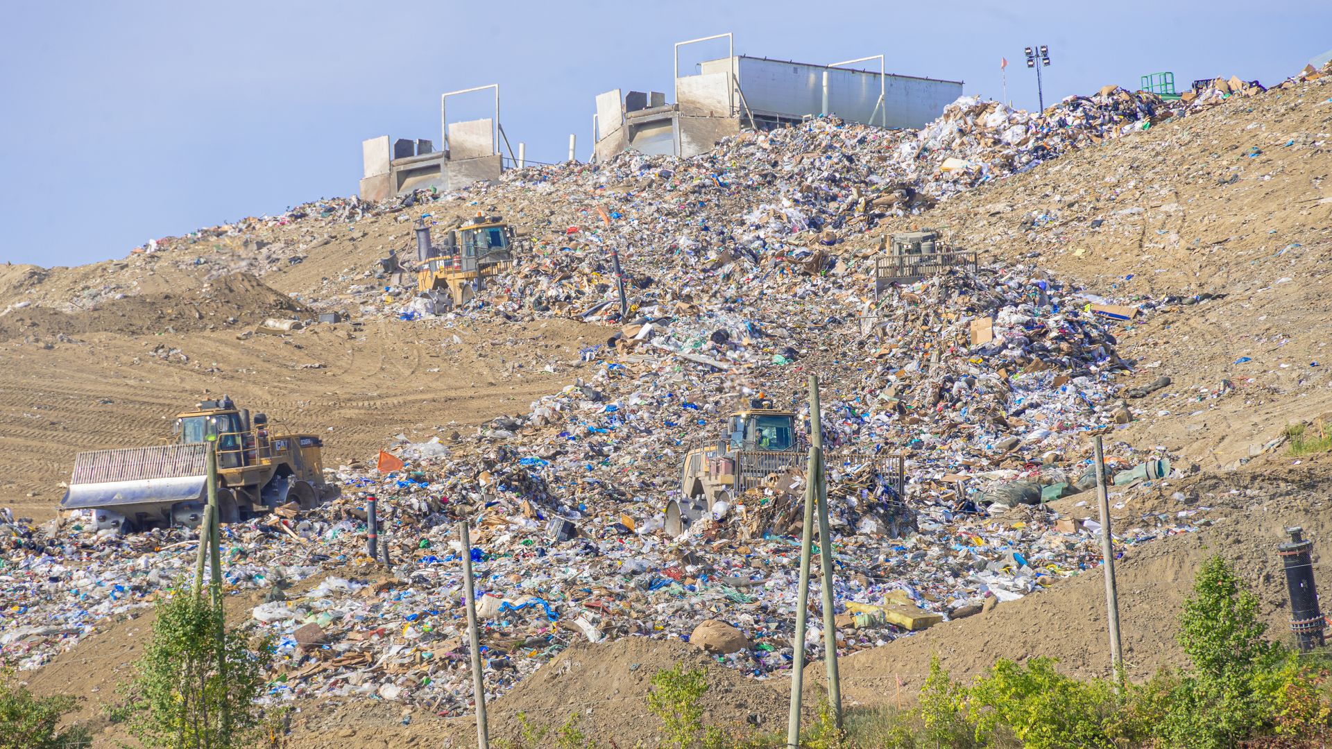 A truck full of trash prepares to tip its trailer back and contribute to a growing pile of trash falling down into the Franklin County Sanitary Landfill's working face