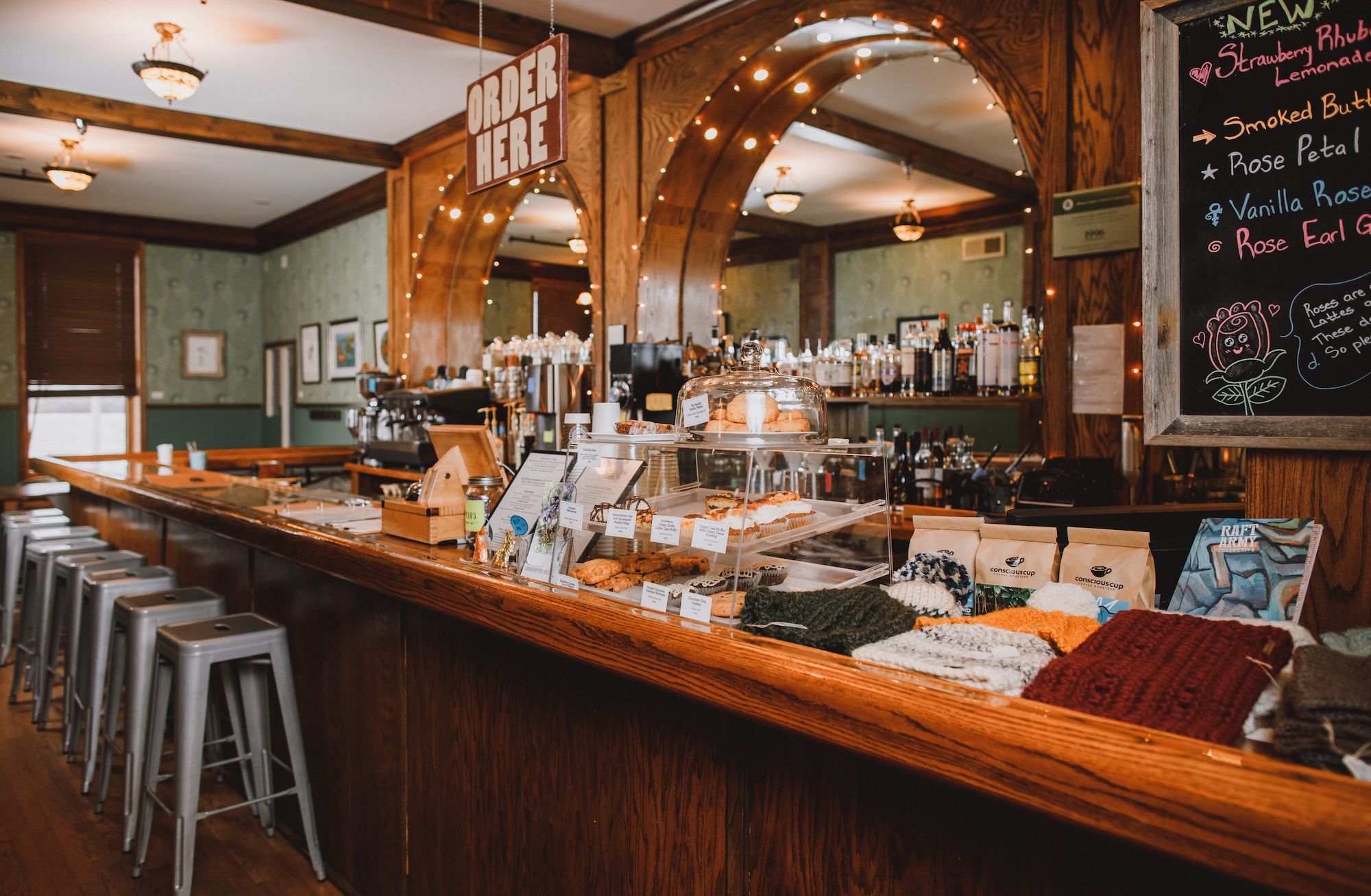 A wood bar with goods on the counter and a sign that reads Order Here