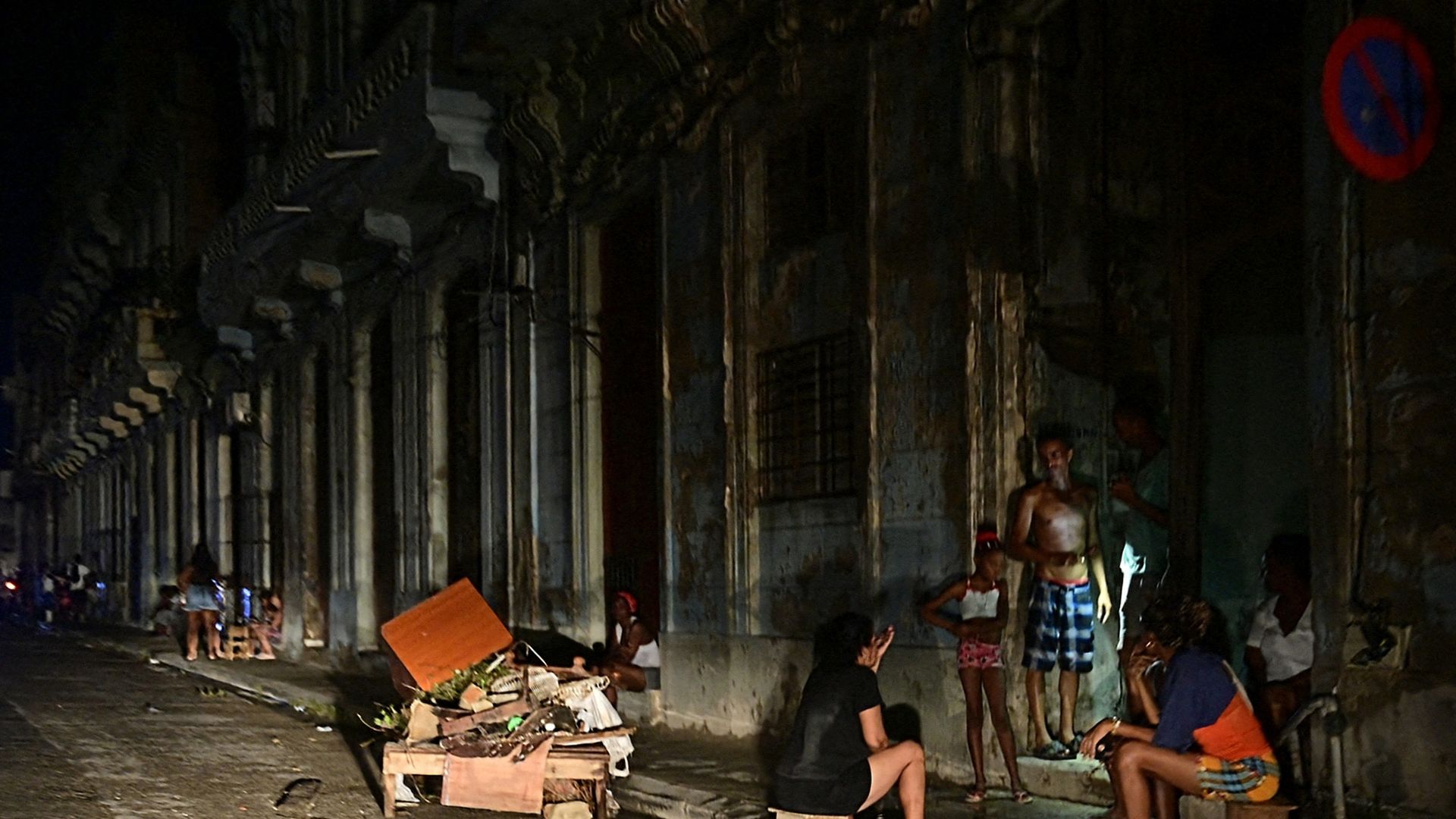 A few people are seen standing outside in the dark during a blackout in Cuba