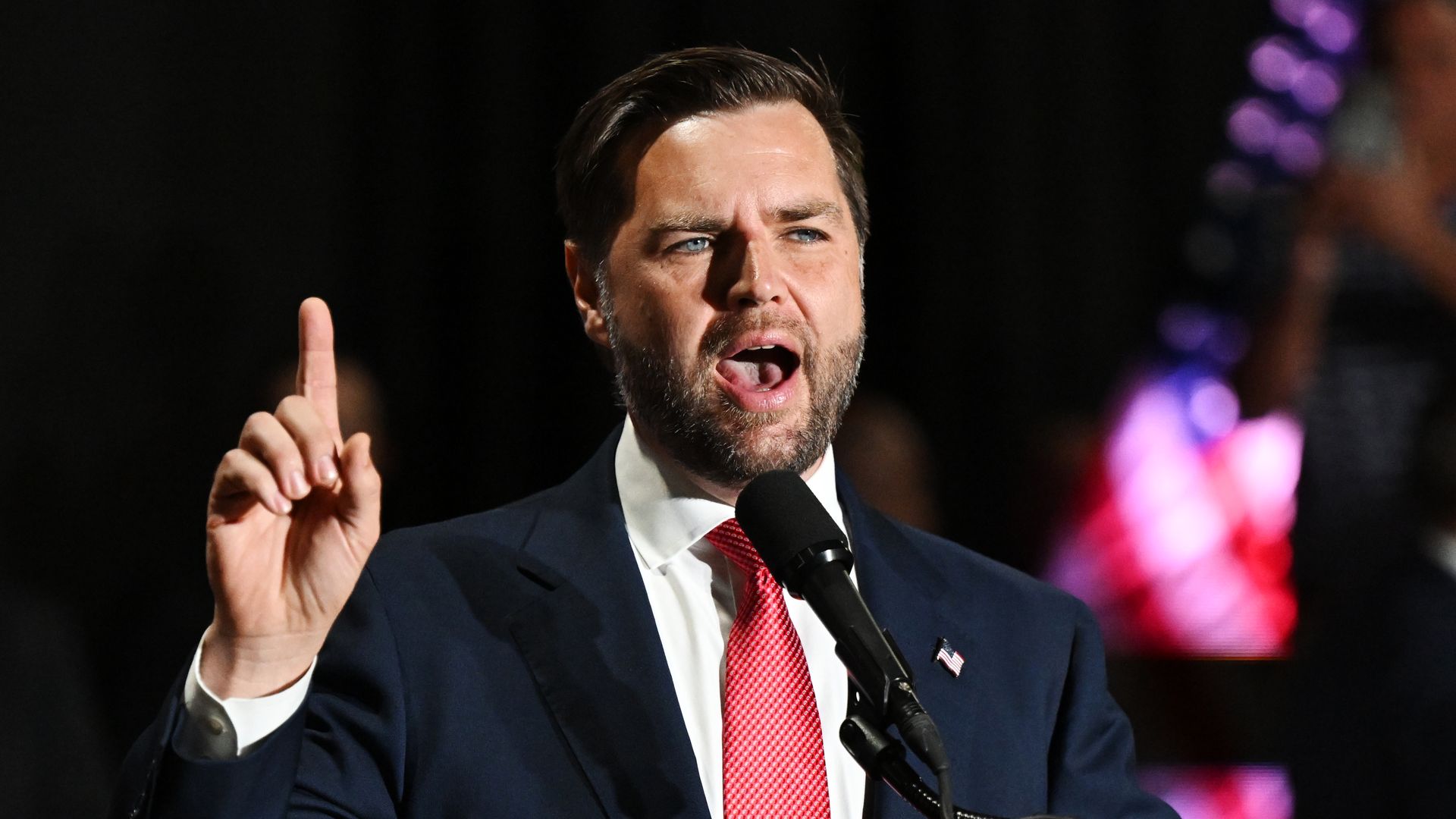 JD Vance, in a blue suite, white shirt, red tie