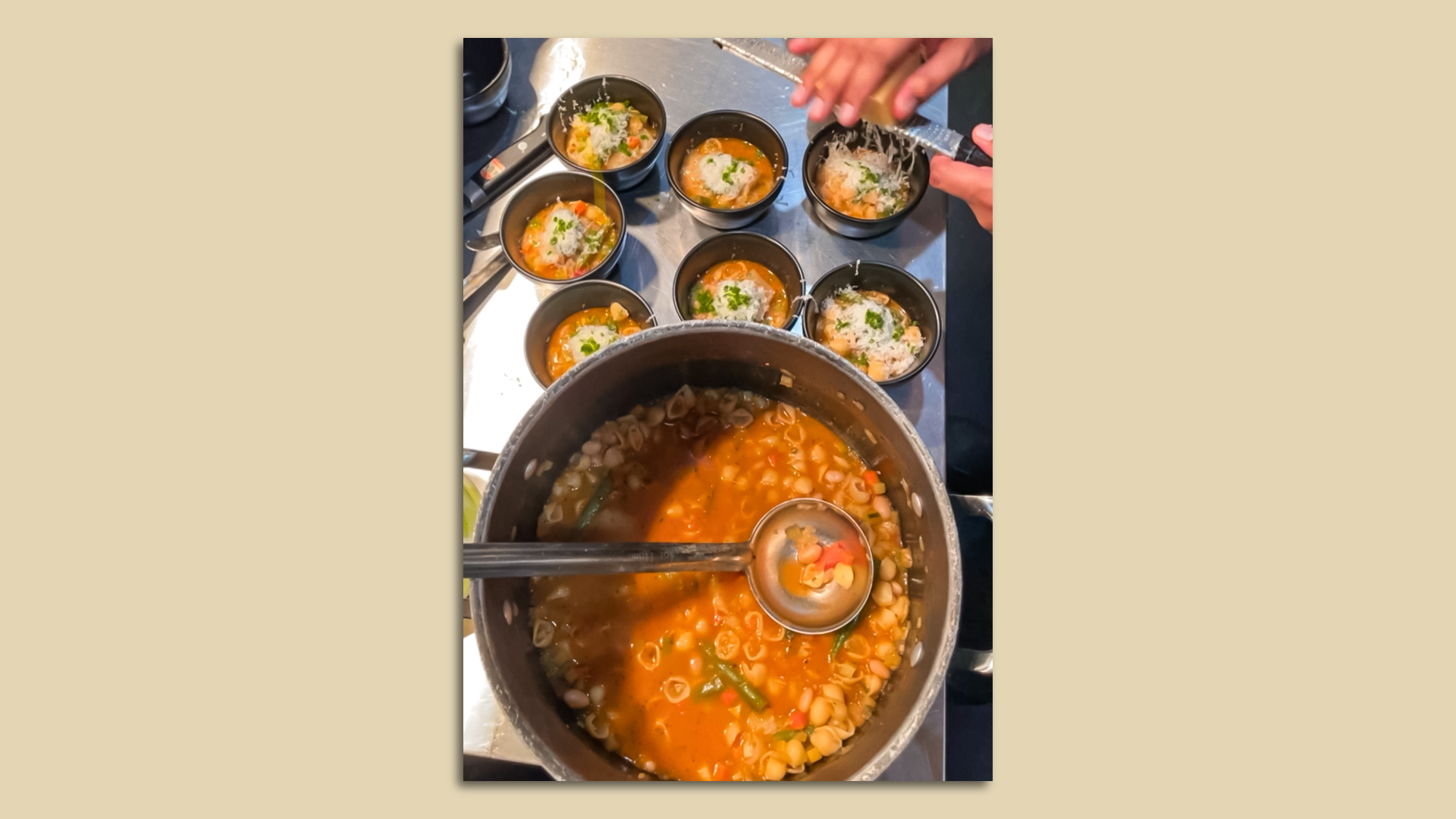 A large pot of vegetable soup surrounded by smaller portions. 